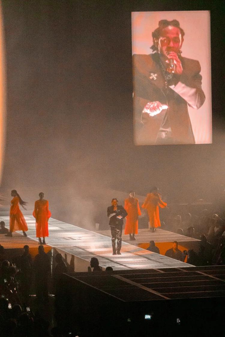 Performer with backup dancers in orange
