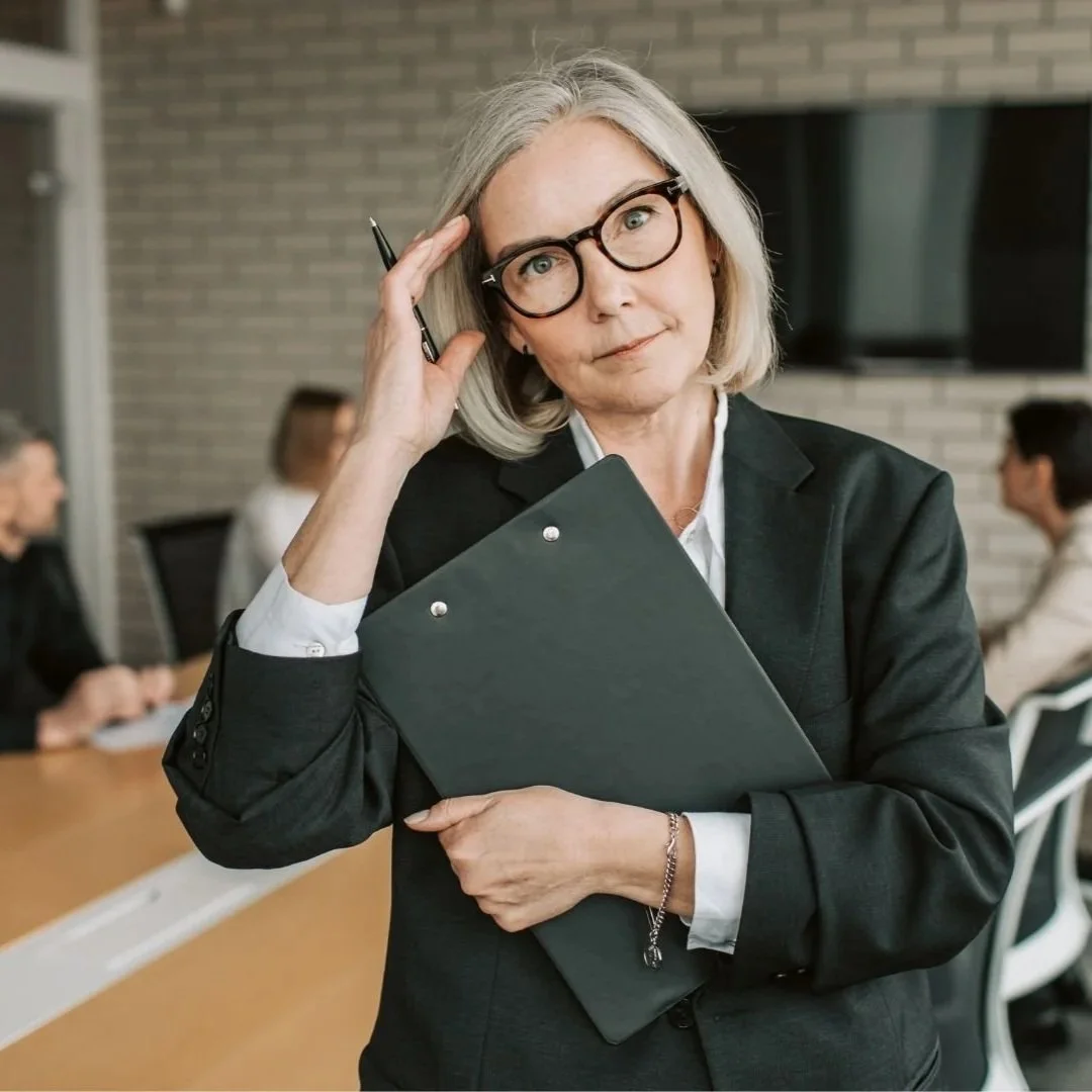 Mature woman with glasses in a corporate blazer