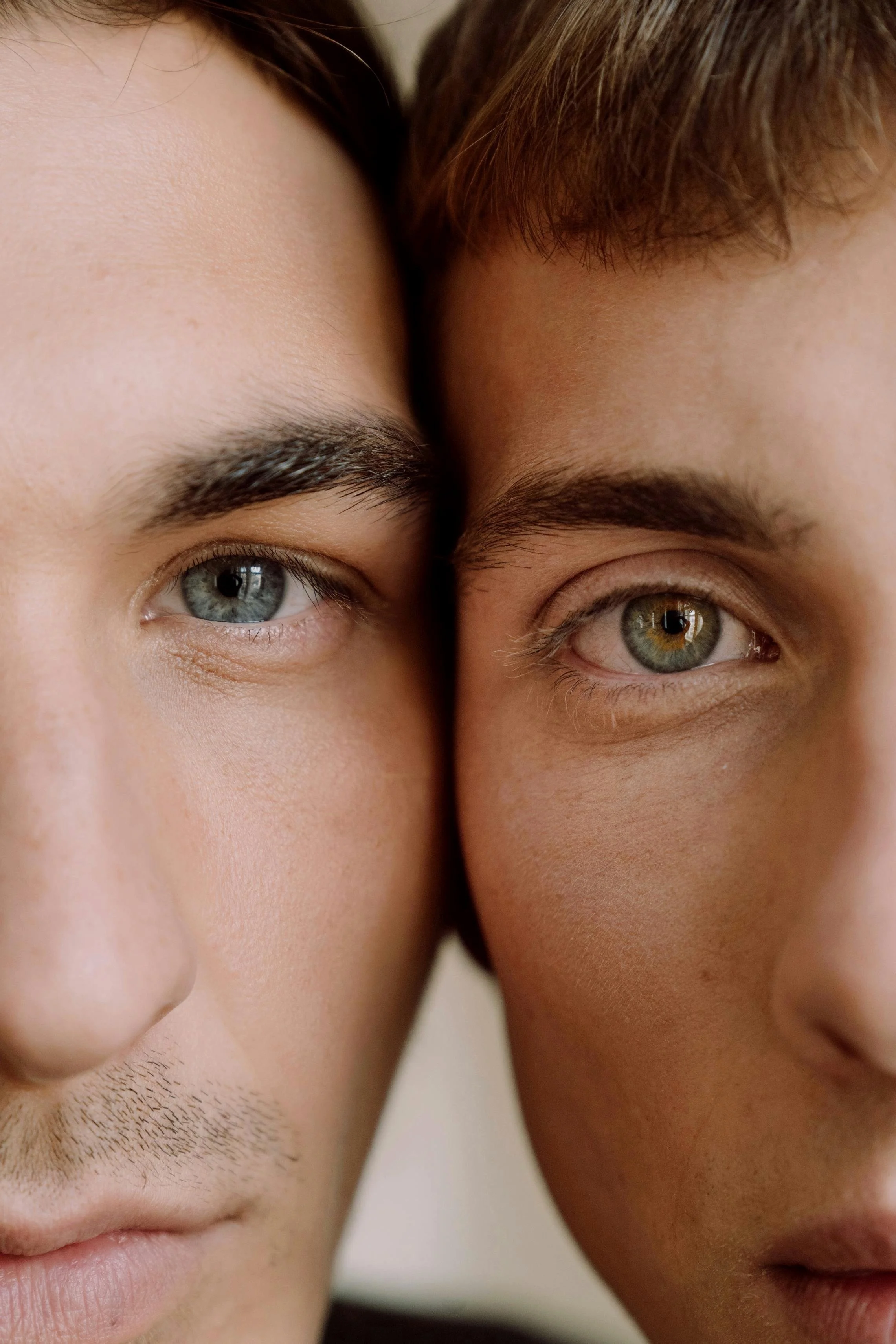Close-up of two men's faces with their foreheads touching, showing their eyes, eyebrows, and part of their noses.