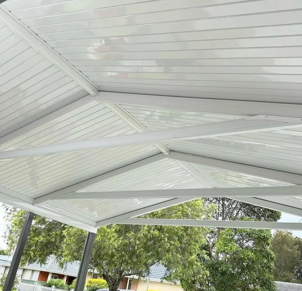 White metal roof with supports and trees in the background.