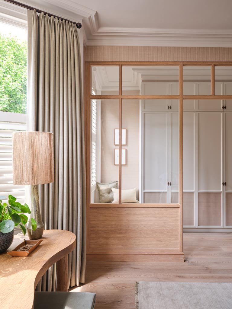 Calm primary bedroom with period windows and custom joinery