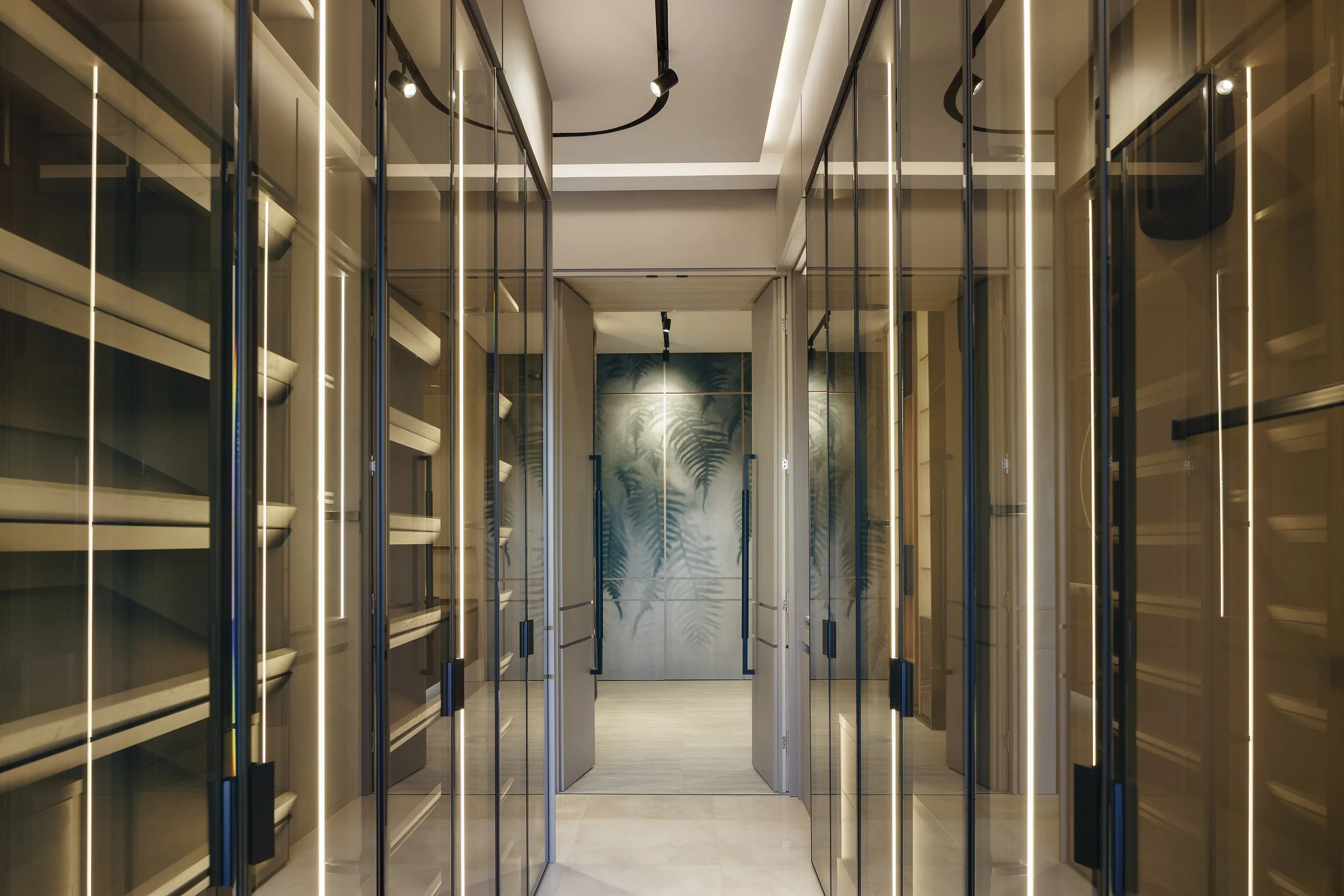 Pasillo con paredes de espejo y estanterías de madera en ambos lados, iluminación moderna y decoración minimalista con planta en la pared al fondo