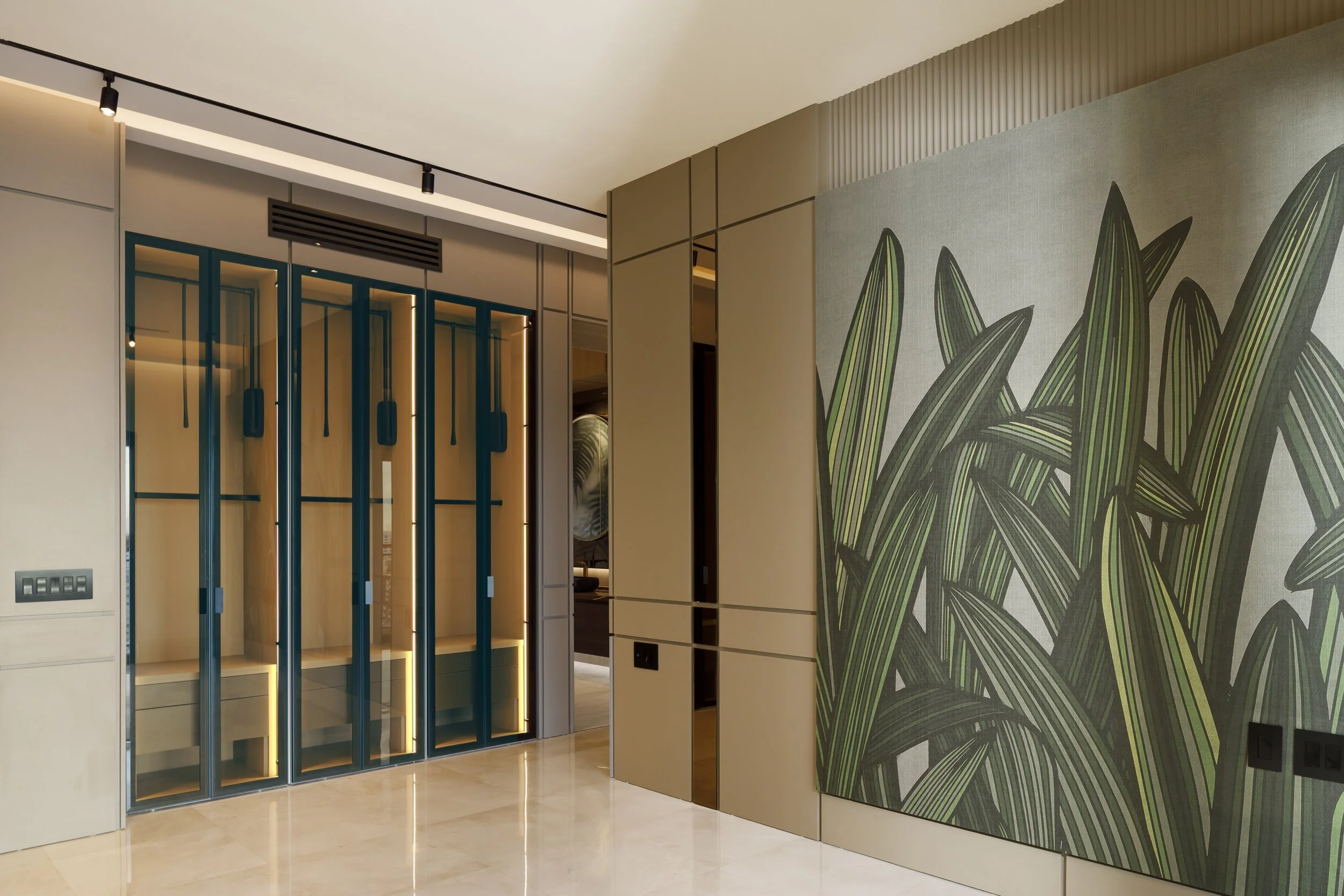 Interiores modernos de un edificio con paredes decoradas con un mural de plantas y una puerta de vidrio con marco azul.