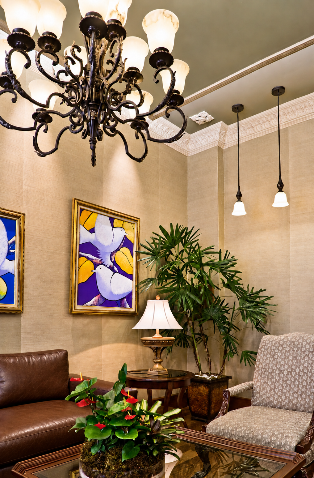 Detalle de la sala de espera de SEEPID, con arte, vegetación y sofá en piel marrón.