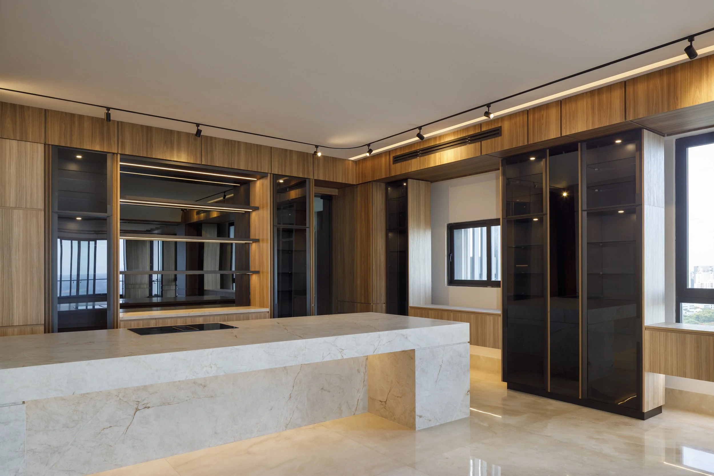 Interior moderno de sala con paredes de madera, ventanas grandes y mostradores de piedra crema.