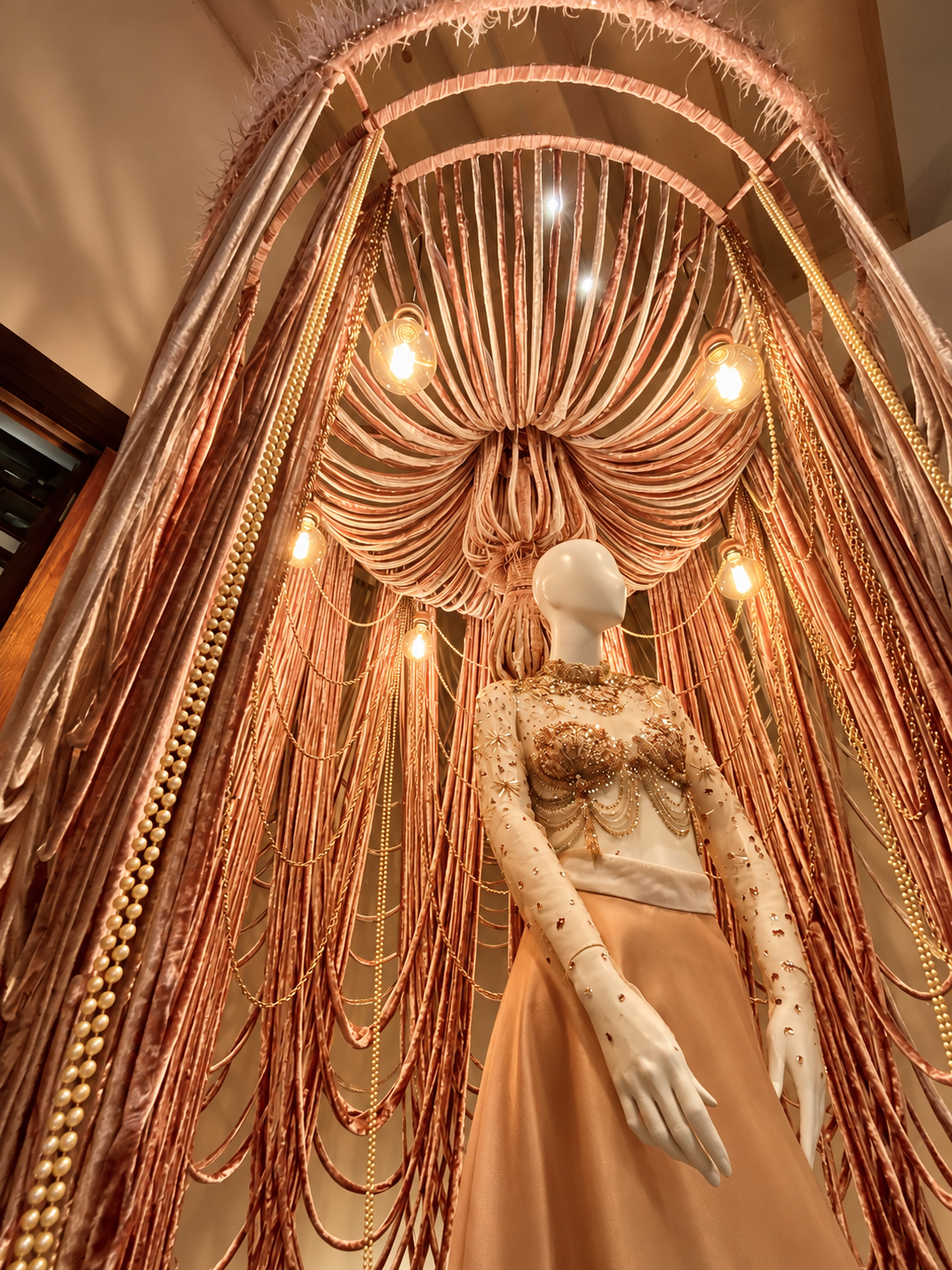 Maniquí femenino en contrapicado bajo la iluminación escenográfica del stand.