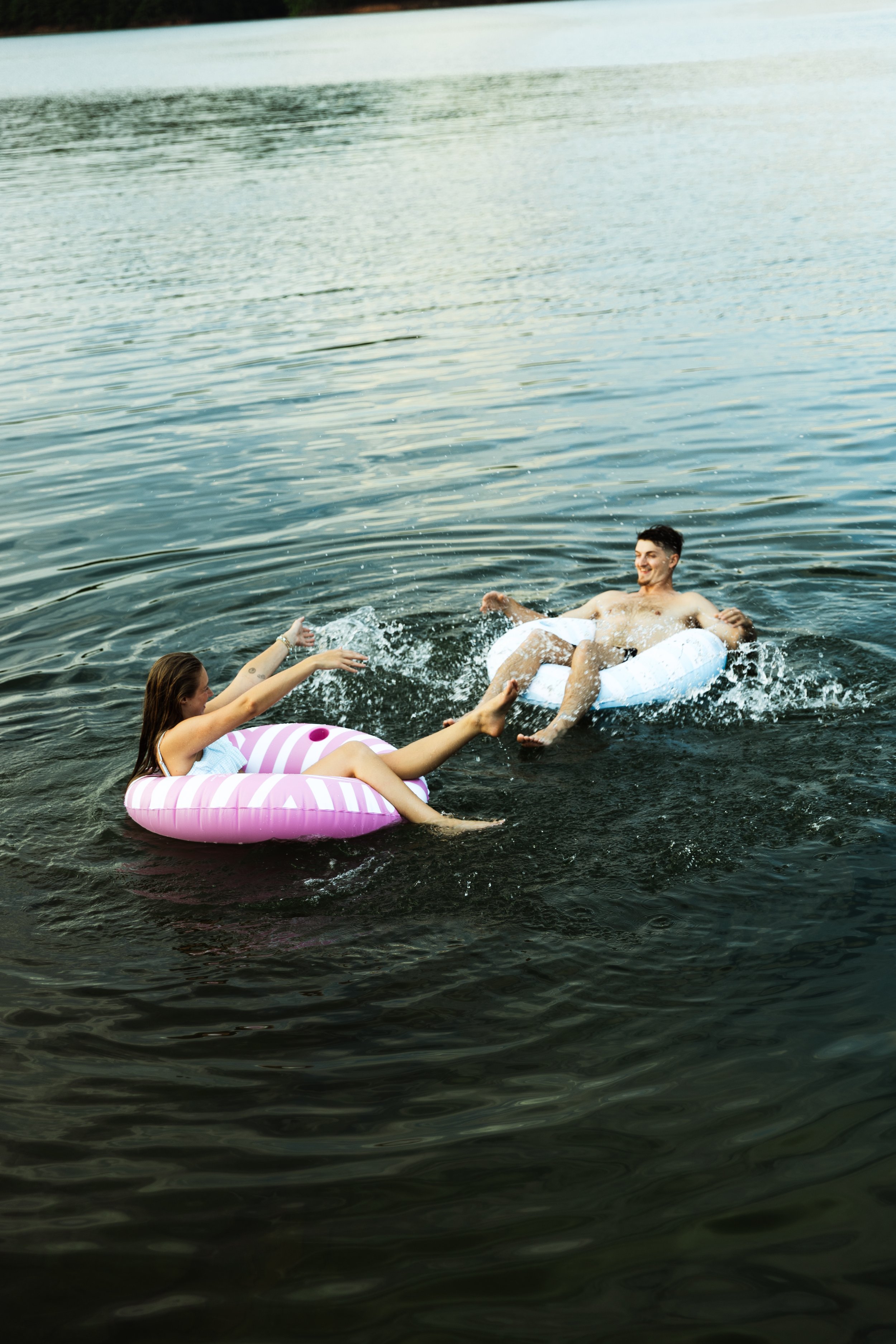 Couple splashing each other in lake