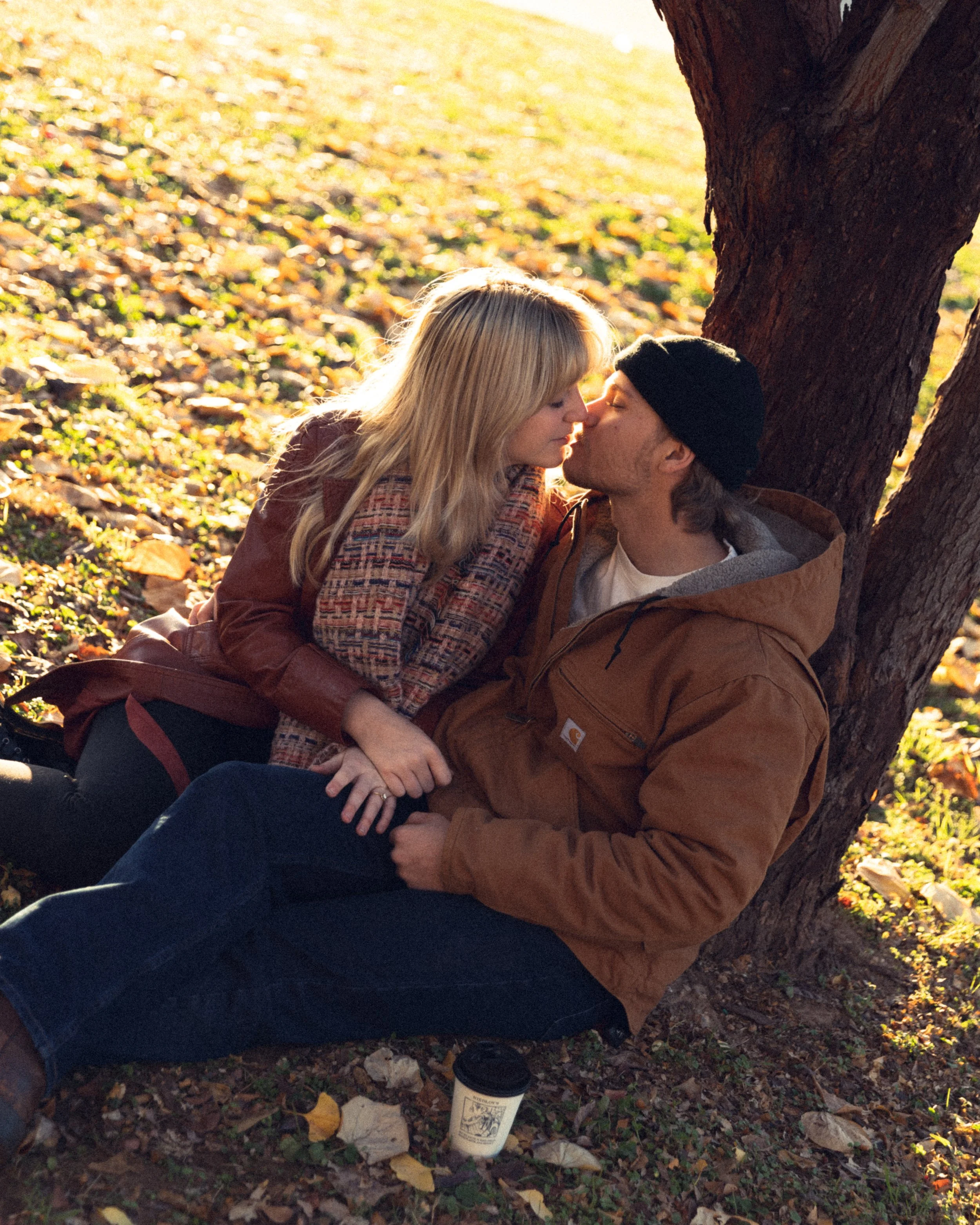 Couple about to kiss under a tree