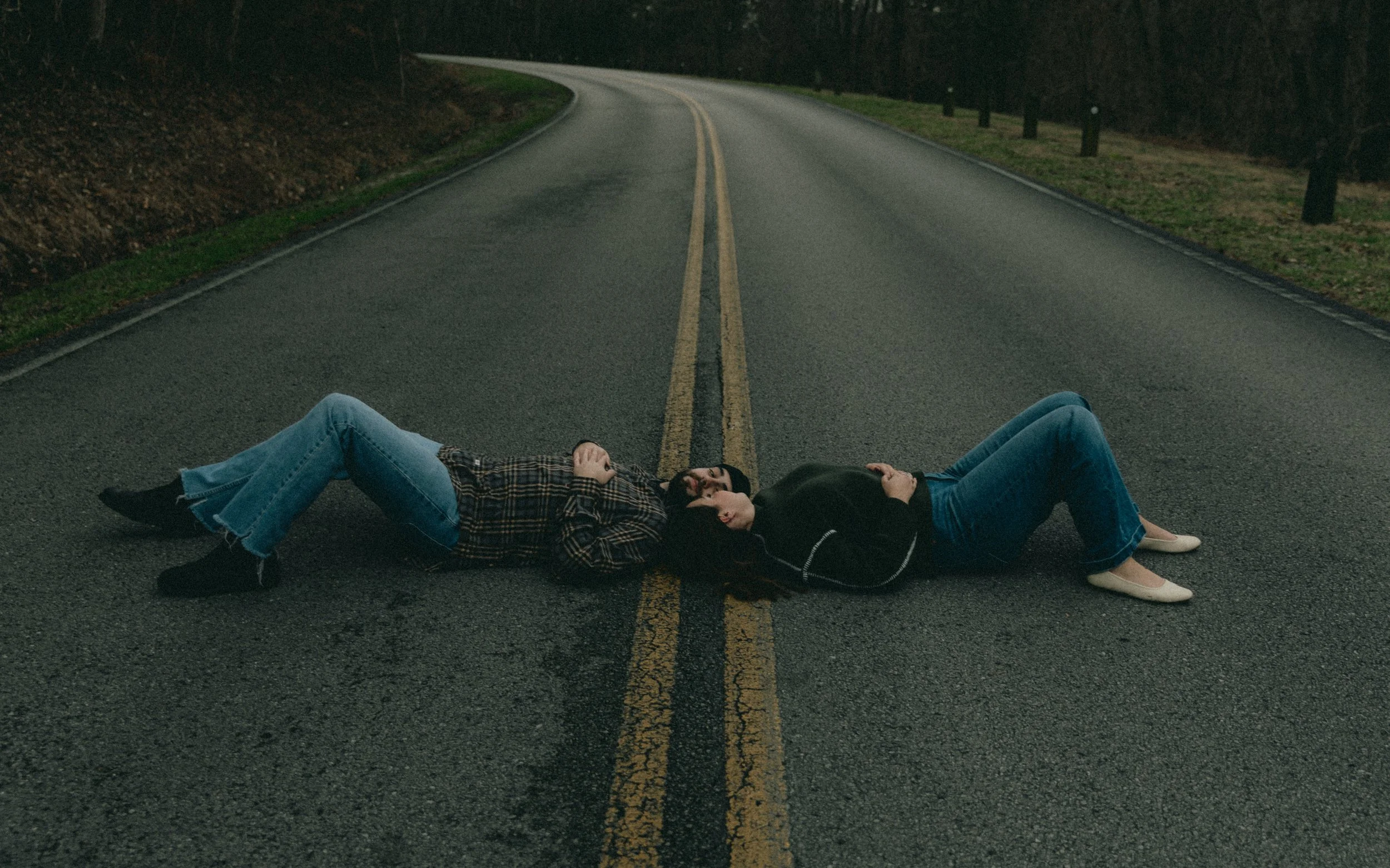 couple laying down in the road