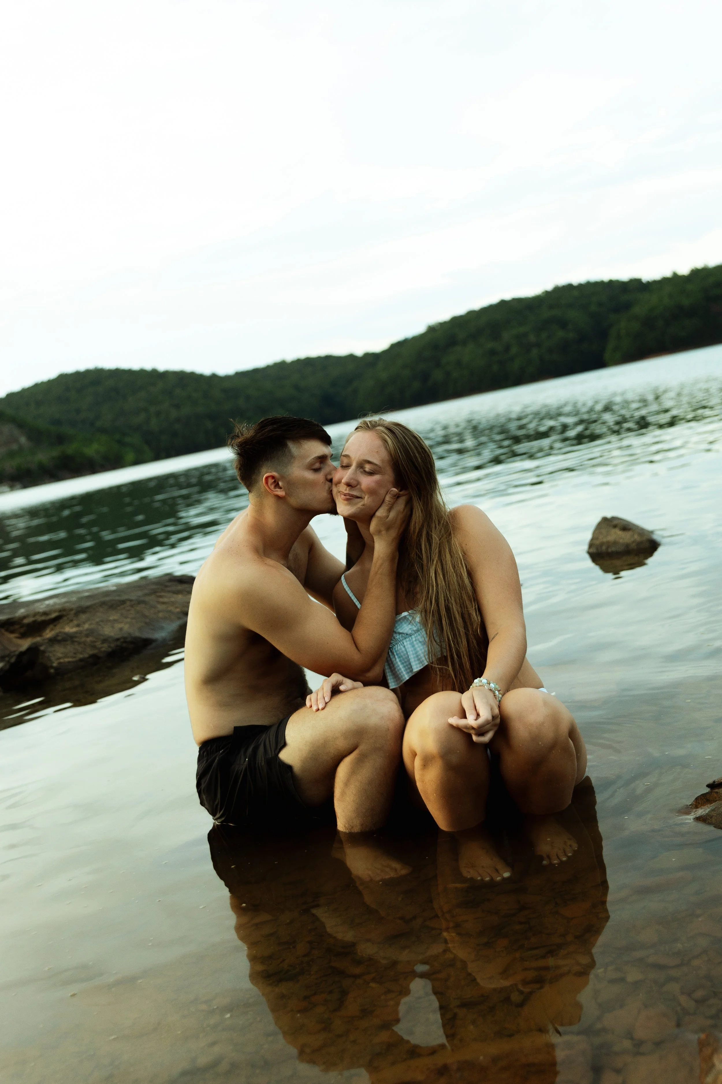 Couple sitting on a rock in lake