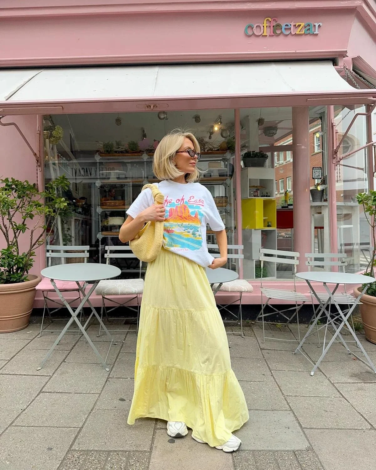 butter yellow maxi skirt paired with a white graphic tee and sneaker for an effortless and chic summer outfit for women