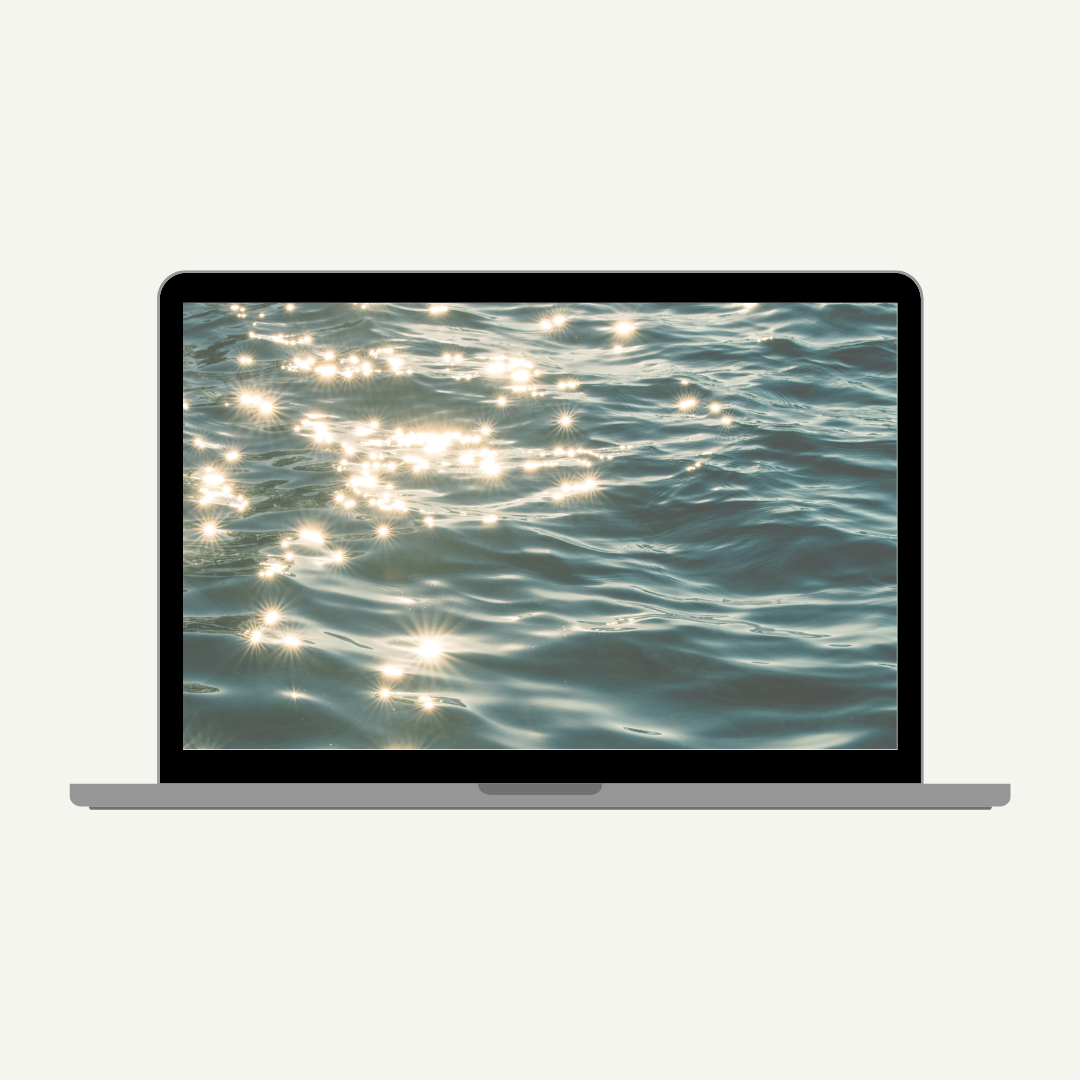 a beautiful shimmering body of blue water displayed as the background on this laptop computer