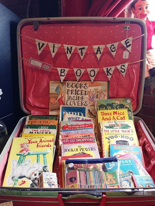 a thrifted suitcase that is filled with vintage children's books for a classroom