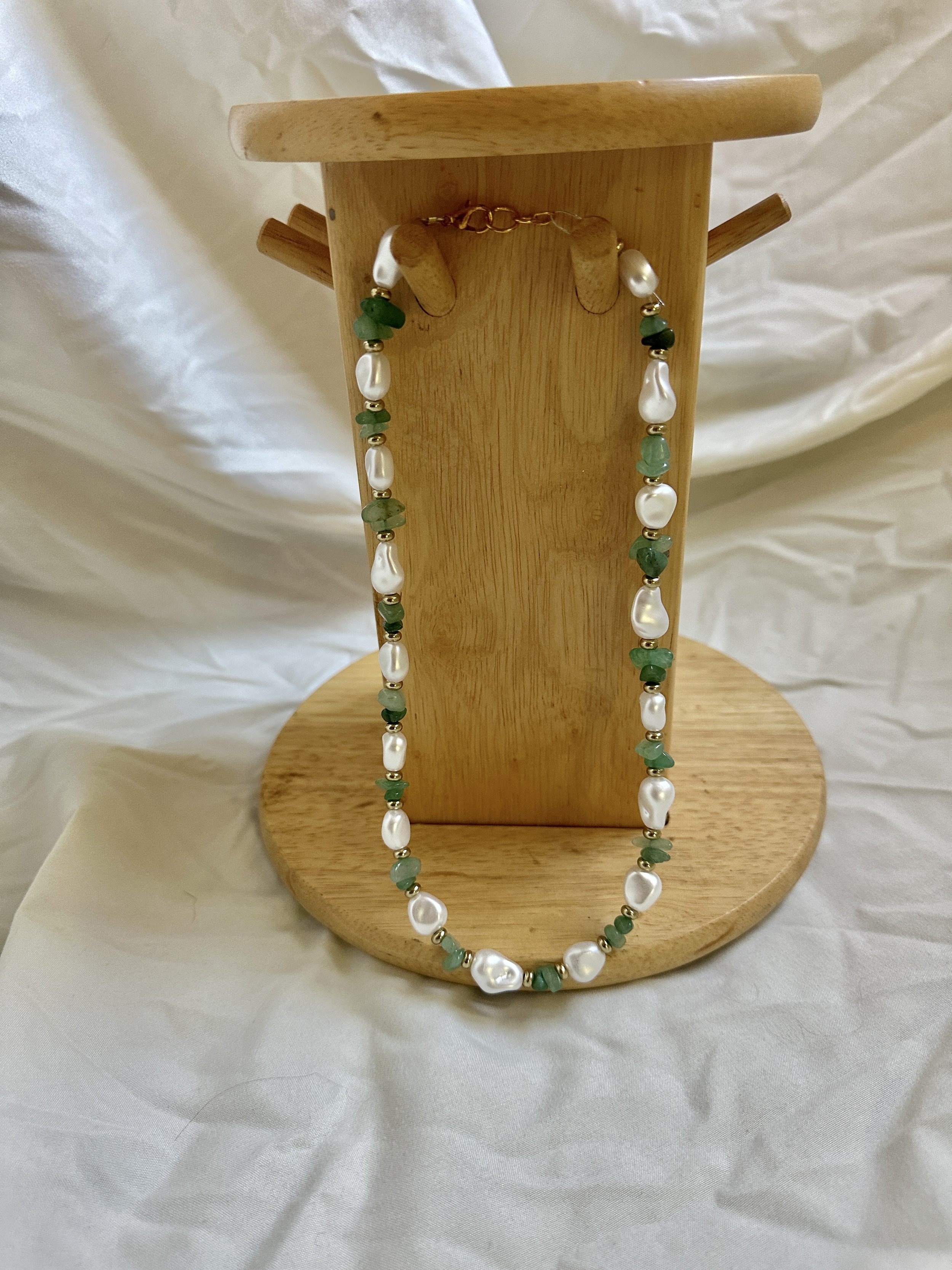 a unique one of a kind necklace for women using various beads including gold coins, jade beads, and pearl beads. a elegant yet casual aesthetic that will match every outfit