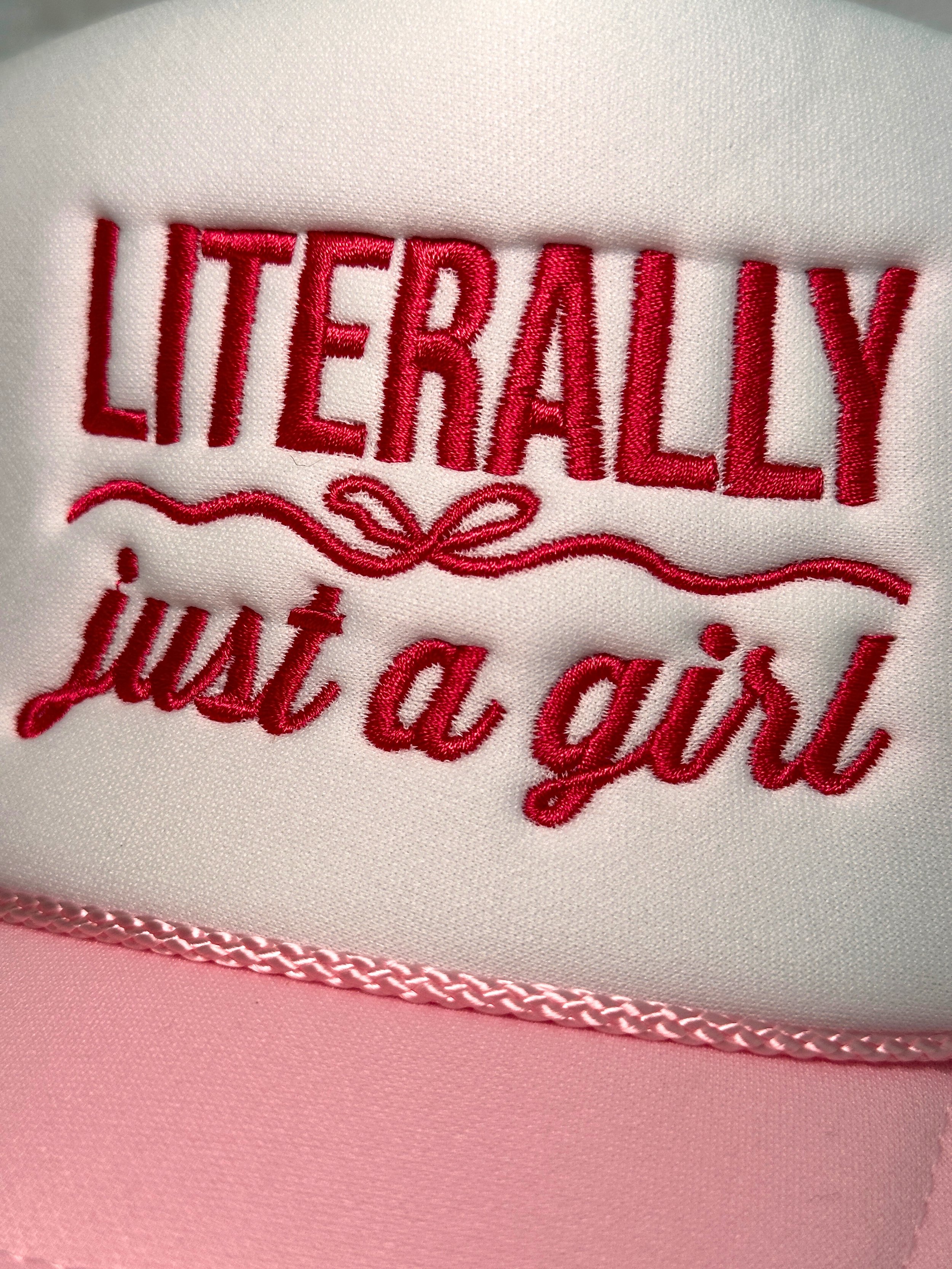 close up image of pink embroidered lettering on pink and white trucker hat