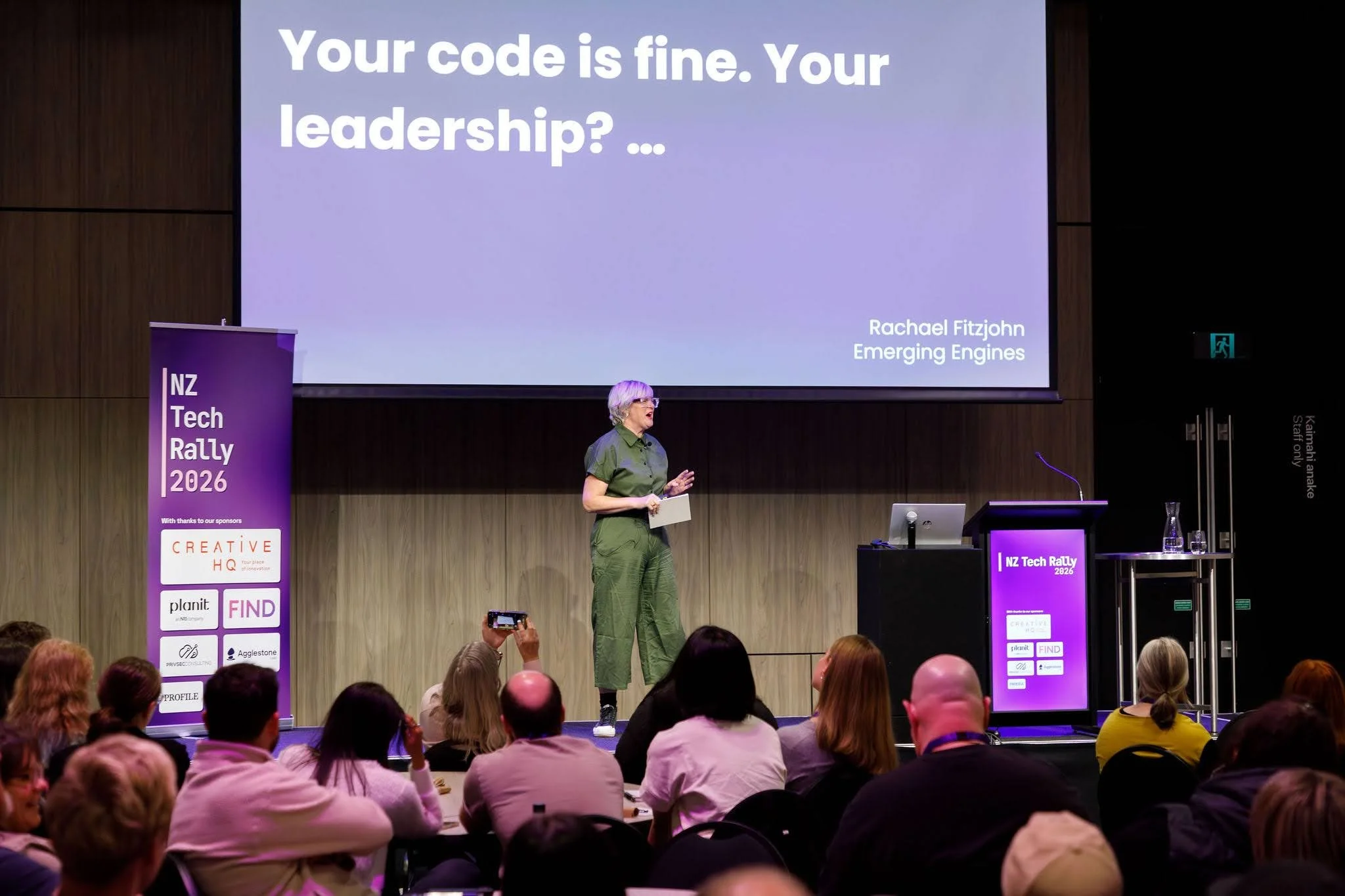 Rachael Fitzjohn on stage giving her talk at NZ Tech Rally 2026. the screen reads: Your code is fine. Your leadership? ...