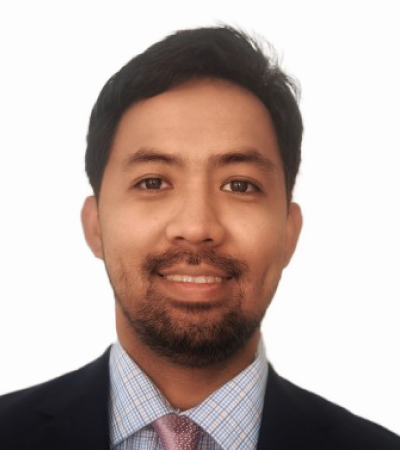 Headshot of Allan - Allan has medium tone skin, dark hair and beard. He is wearing a formal suit and smiling at the camera.