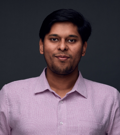Kunal is an Indian male with short dark hair and dark brown eyes, wearing a pink shirt, and slightly smiling at the camera.