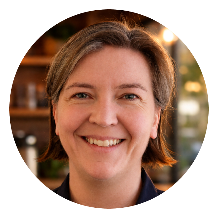 Karen is a middle-aged Caucasian woman, who light brown shoulder length hair. She is wearing a navy top & smiling at the camera.