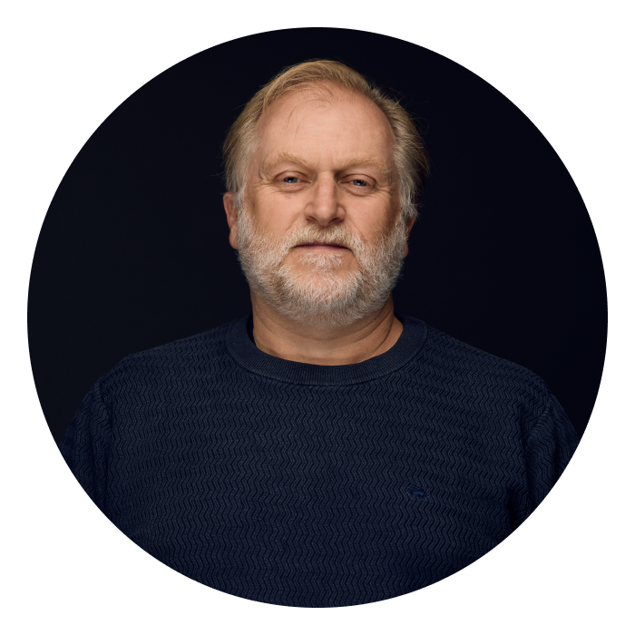 Ben is a middle-aged Caucasian male with short blond hair and grey beard. Ben is wearing a navy jumper and looking at the camera.