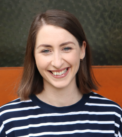 Kelsey is a Caucasian woman with light skin, blue eyes and straight, shoulder-length brown hair.