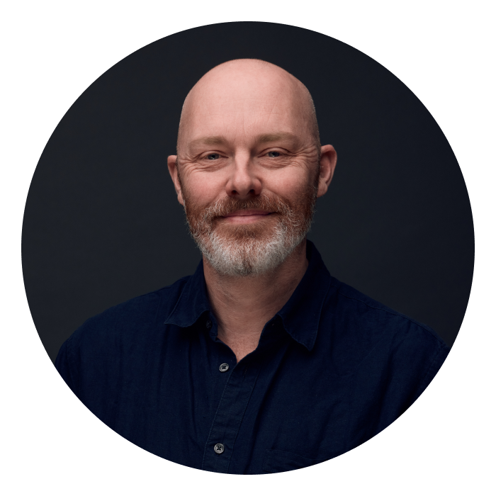 Headshot of Steve Barnett - middle-aged white man, bald, brown beard with white bits, wearing a dark navy shirt..