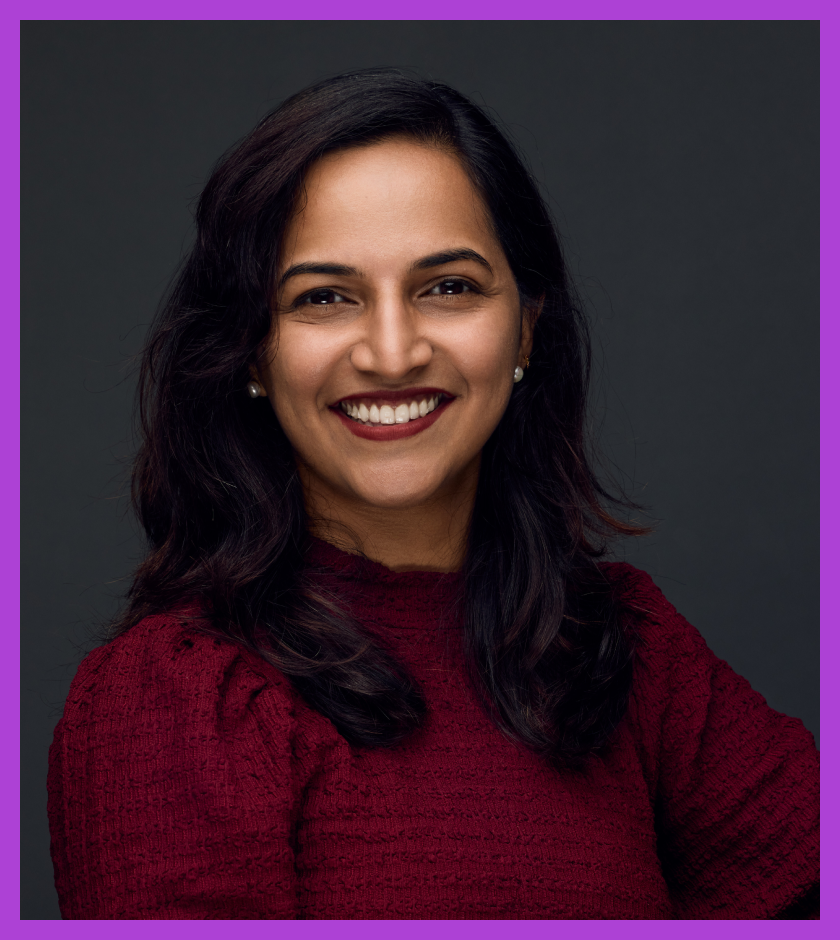A headshot of Ramya, a middle-aged Indian woman with dark hair, wearing a maroon top and a bright smile on her face.