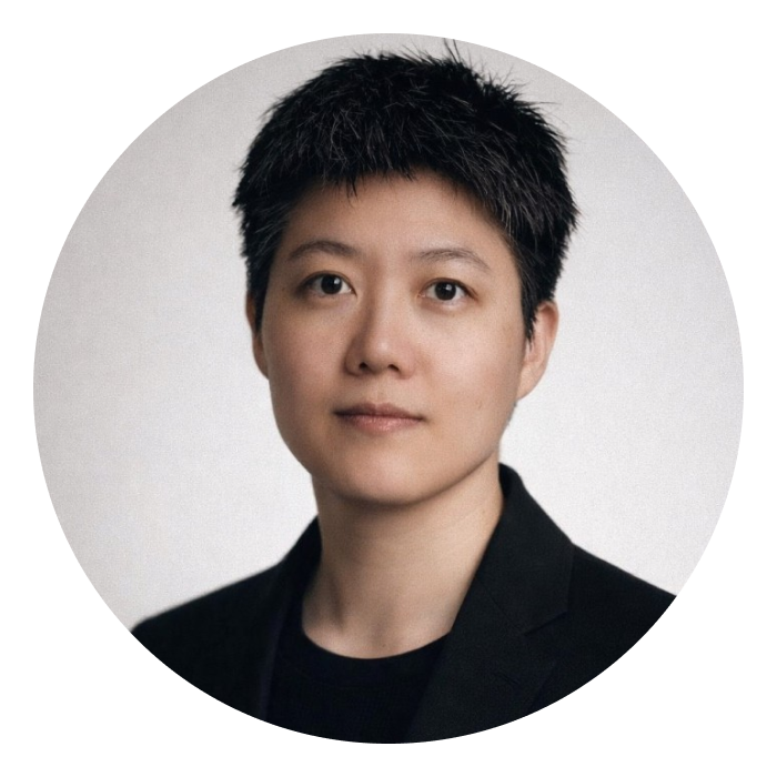 A Chinese woman with short black hair and wearing a black top and black blazer, looking at the camera.