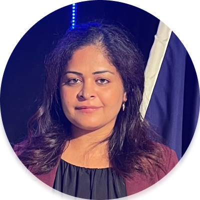 Portrait of Khushi– an Indian woman with dark eyes and dark hair, wearing a black top and a maroon blazer.