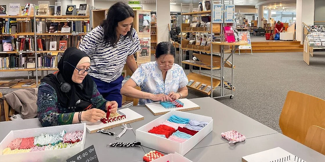 Im Workshop in der Helene Nathan Bibliothek in Neukölln fertigten Besucher:innen aus alten Jersey-Resten kreative Tawashi-Schwämme und Makramee-Anhänger. Die Veranstaltung bot eine gesellige Gelegenheit, handwerkliches Geschick auszuprobieren.