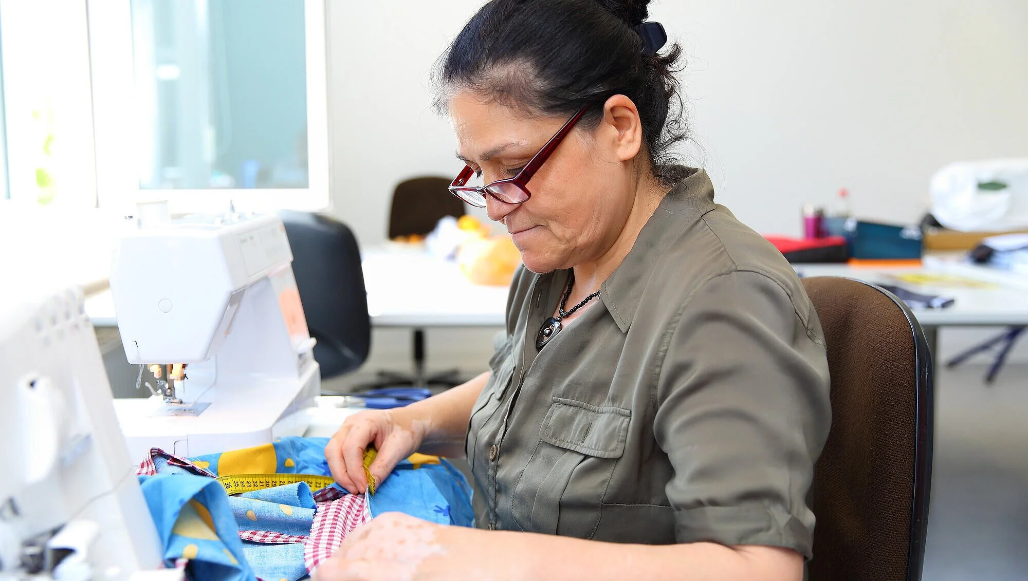 Frau macht Näharbeit mit Unterstützung von „Die Wille“