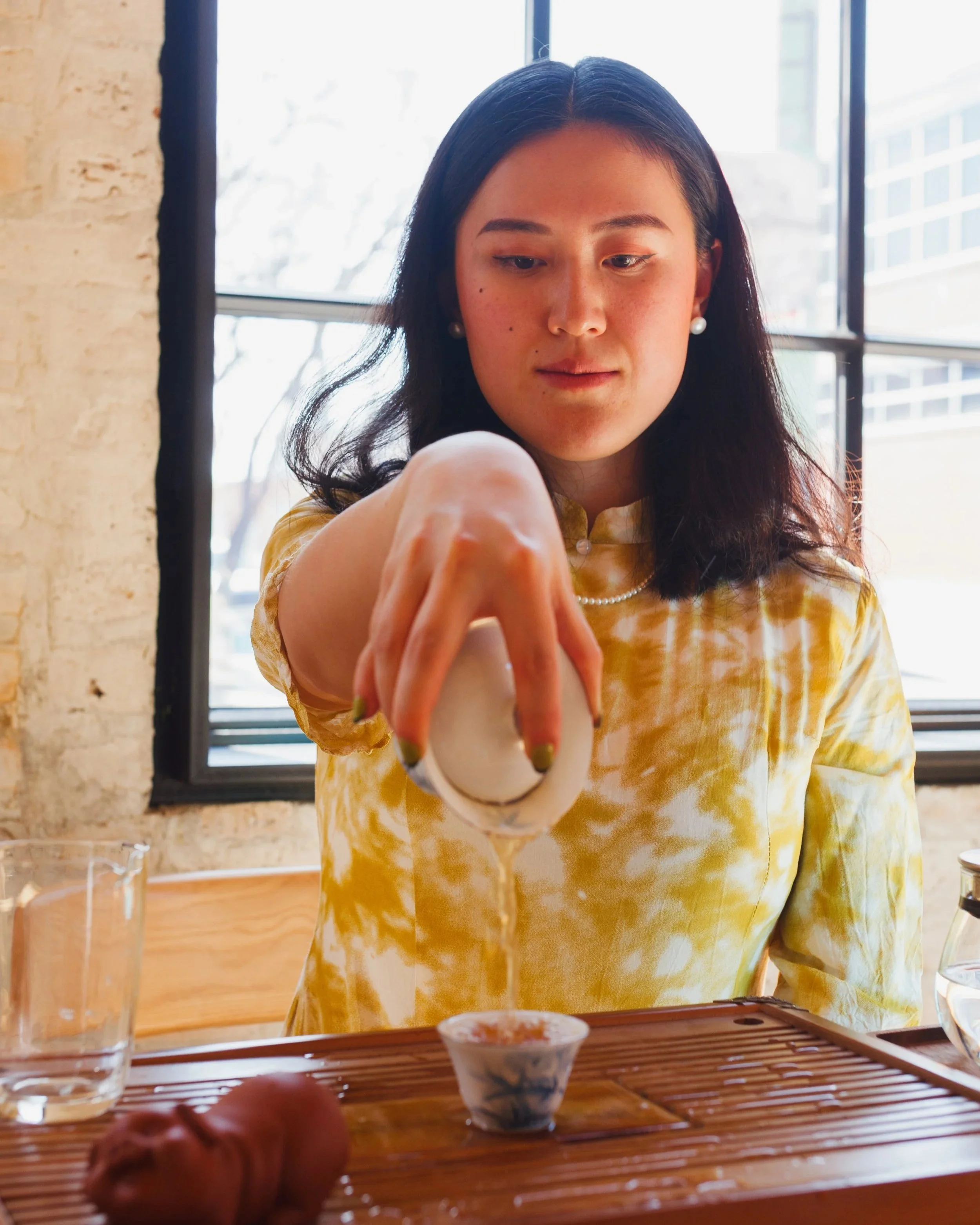 annie, owner of Volition, pouring tea from a gaiwan to a cup