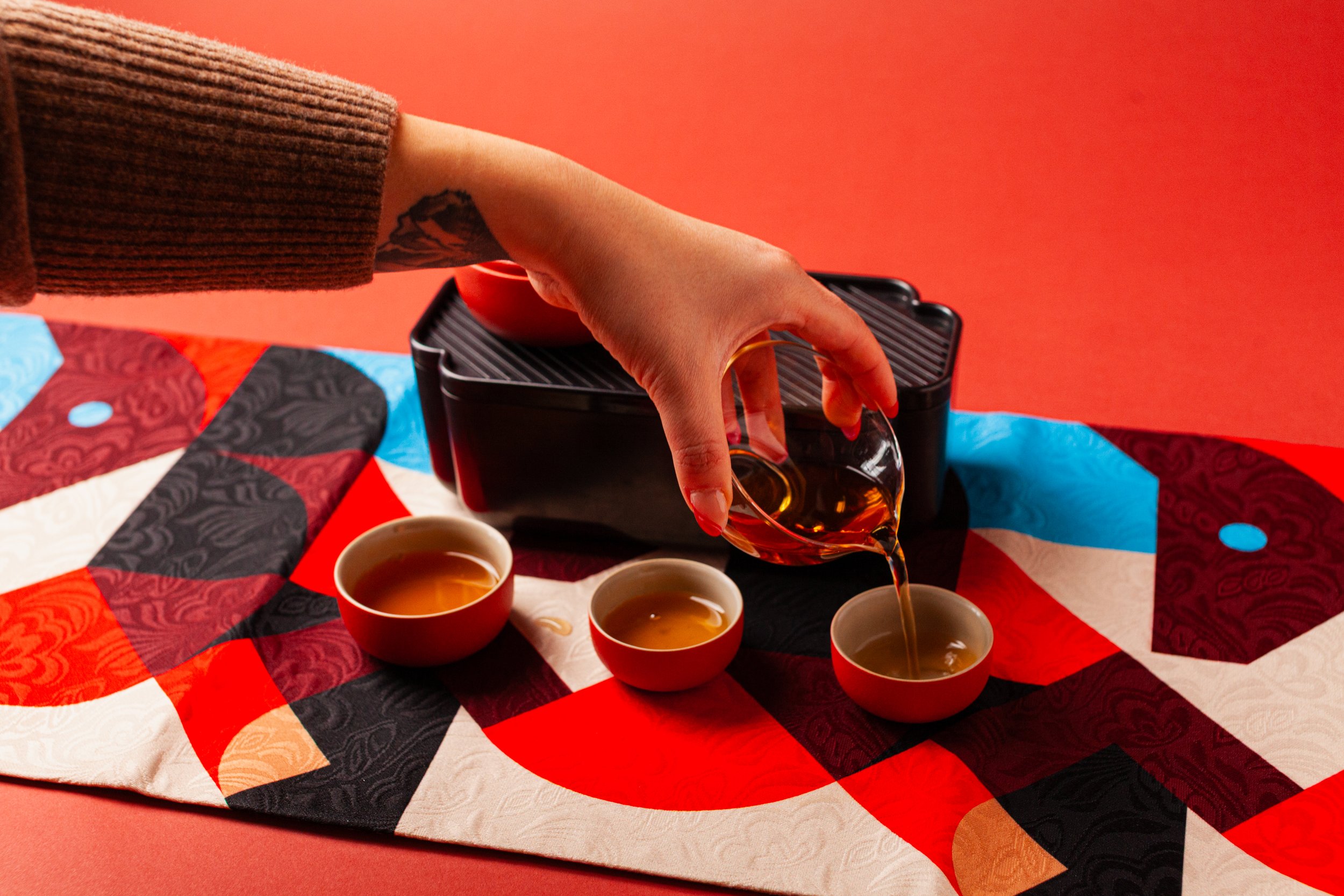 a person pouring tea set on top of fire horse tea towel volition