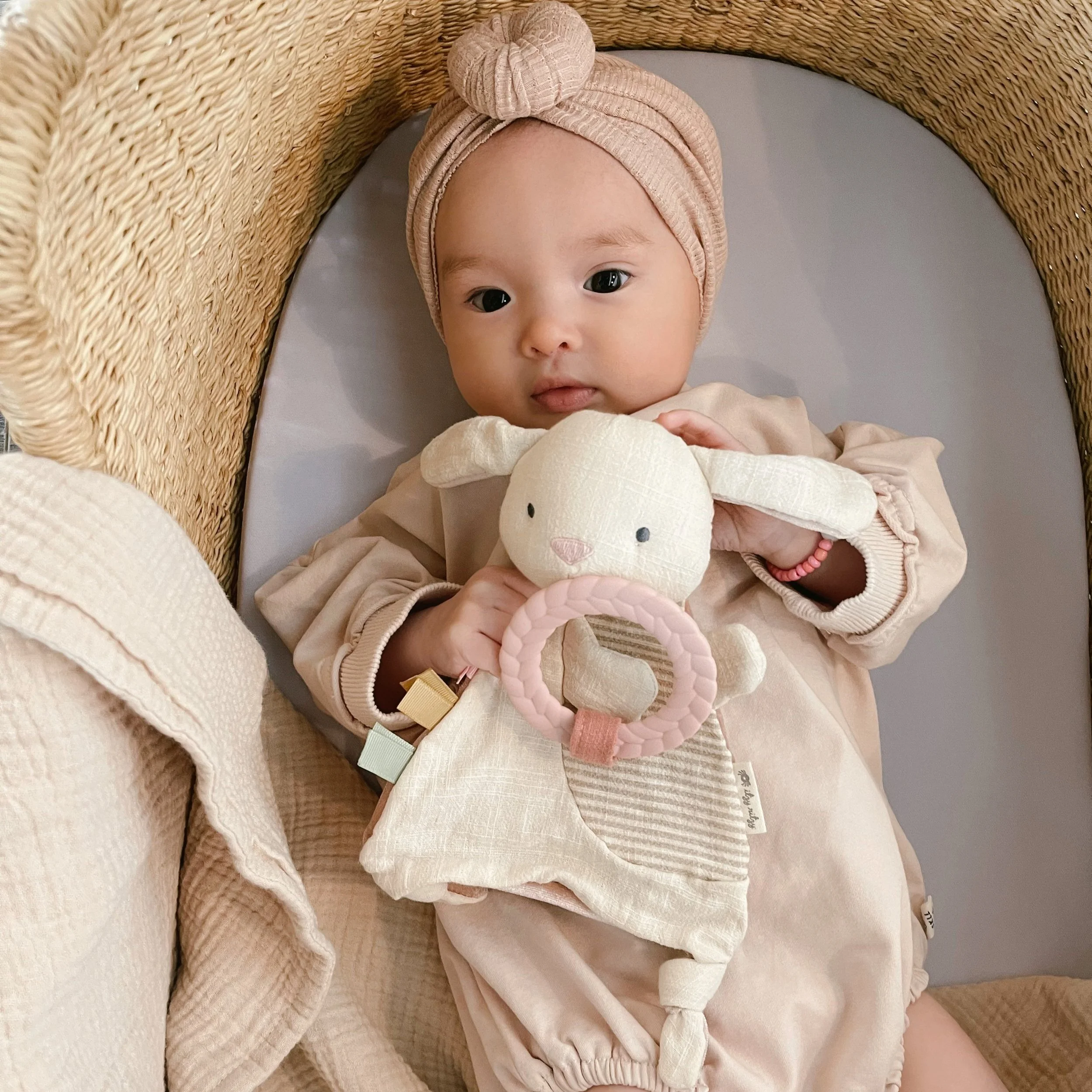 Little girl in pink outfit holding the bitsy crinkle bunny.