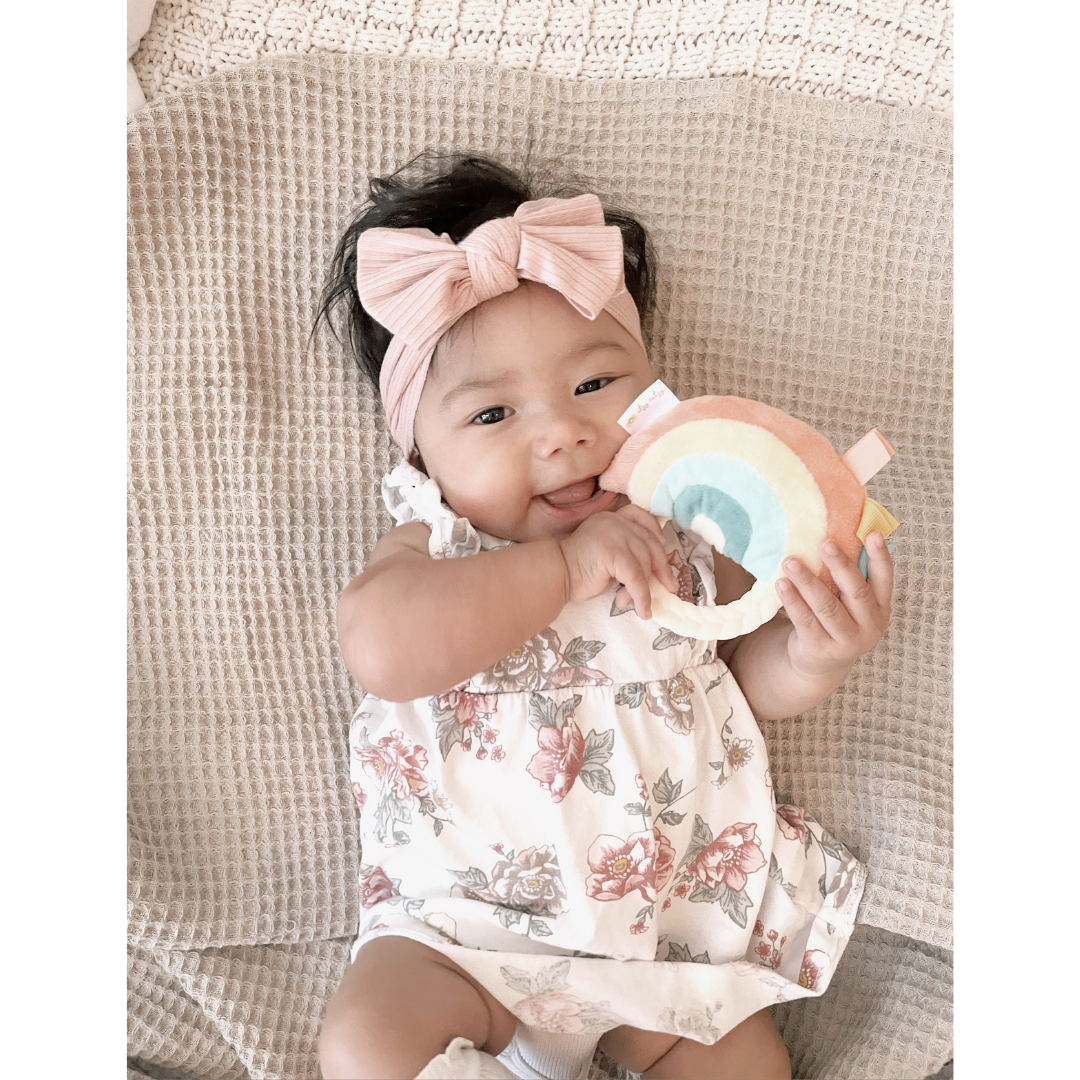 Sweet baby girl playing with the Ritzy Rainbow Rattle Pal.