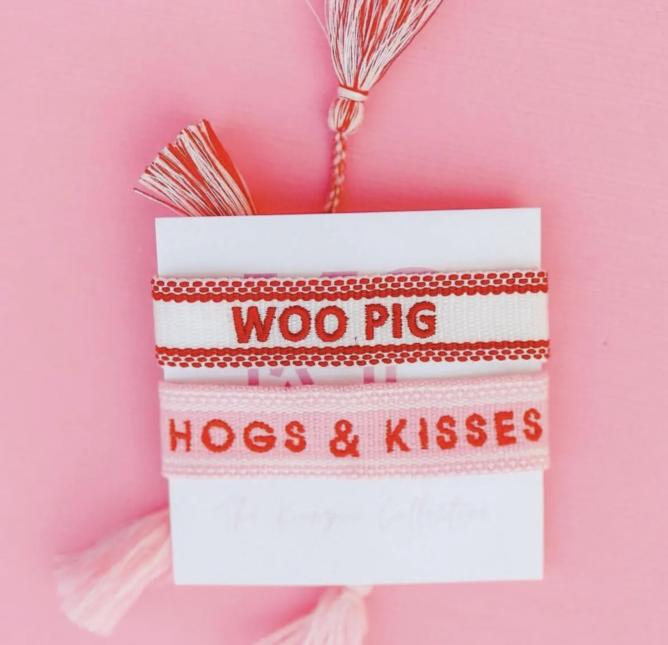 Woo Pig white bracelet on card with Woo Pig embroidered in red. Another bracelet is also pictured.