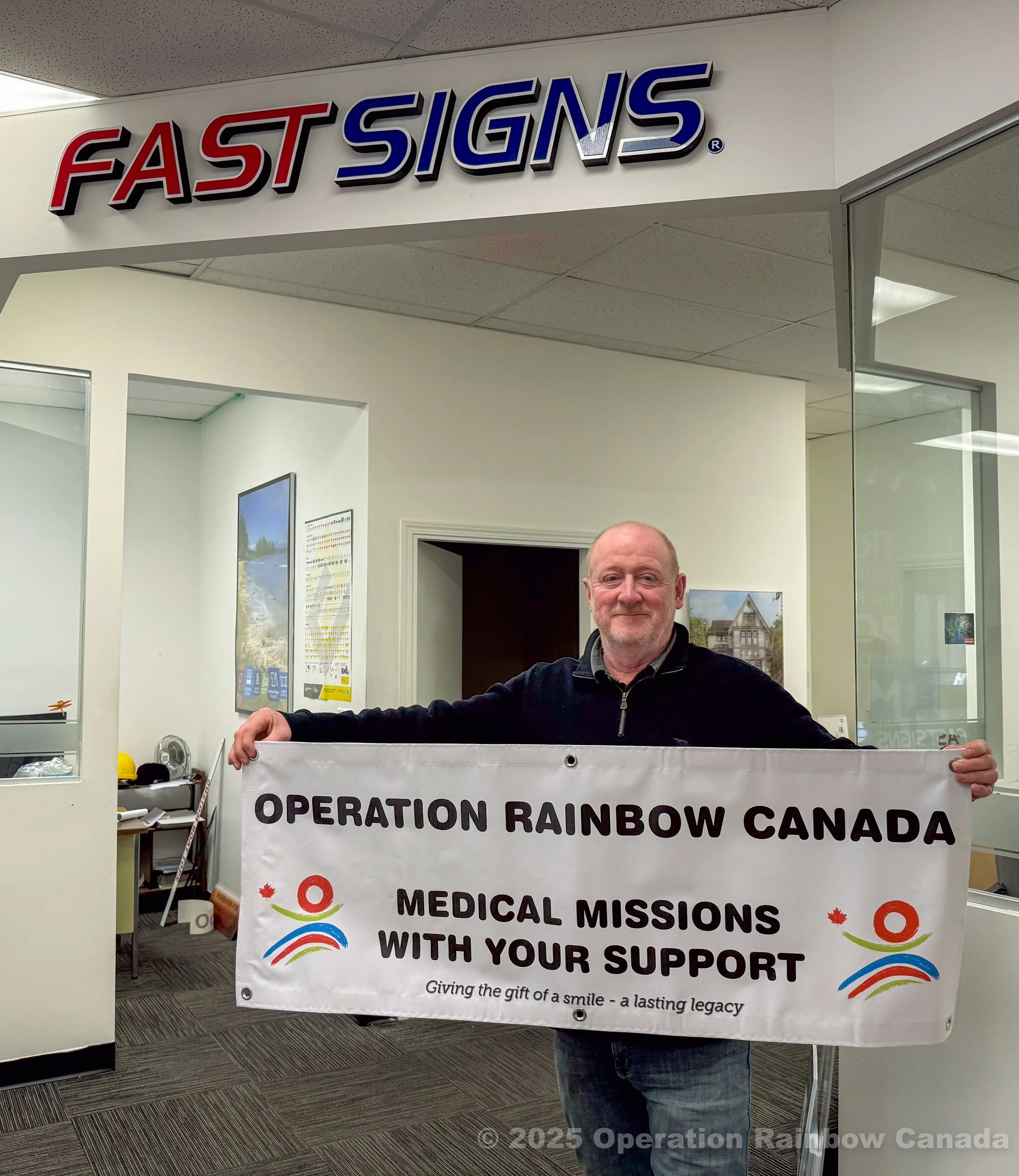 Andrew Crompton of Fast Signs- Coquitlam holding an ORC banner