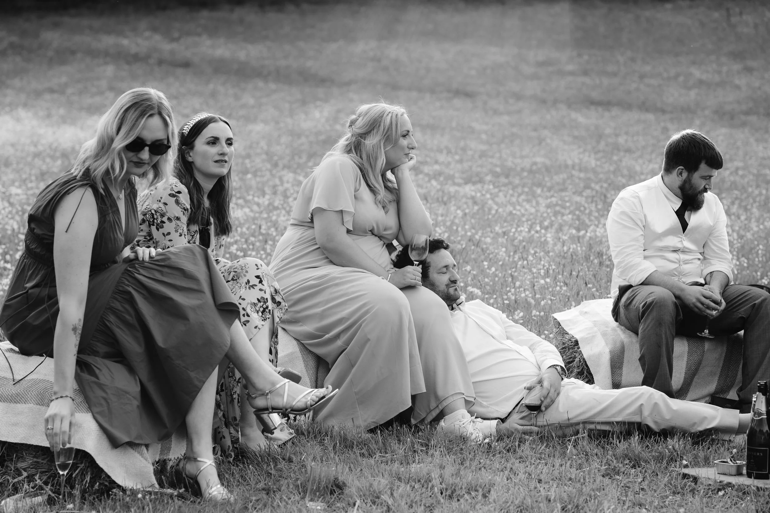 wedding guests relaxing on the grass at reception