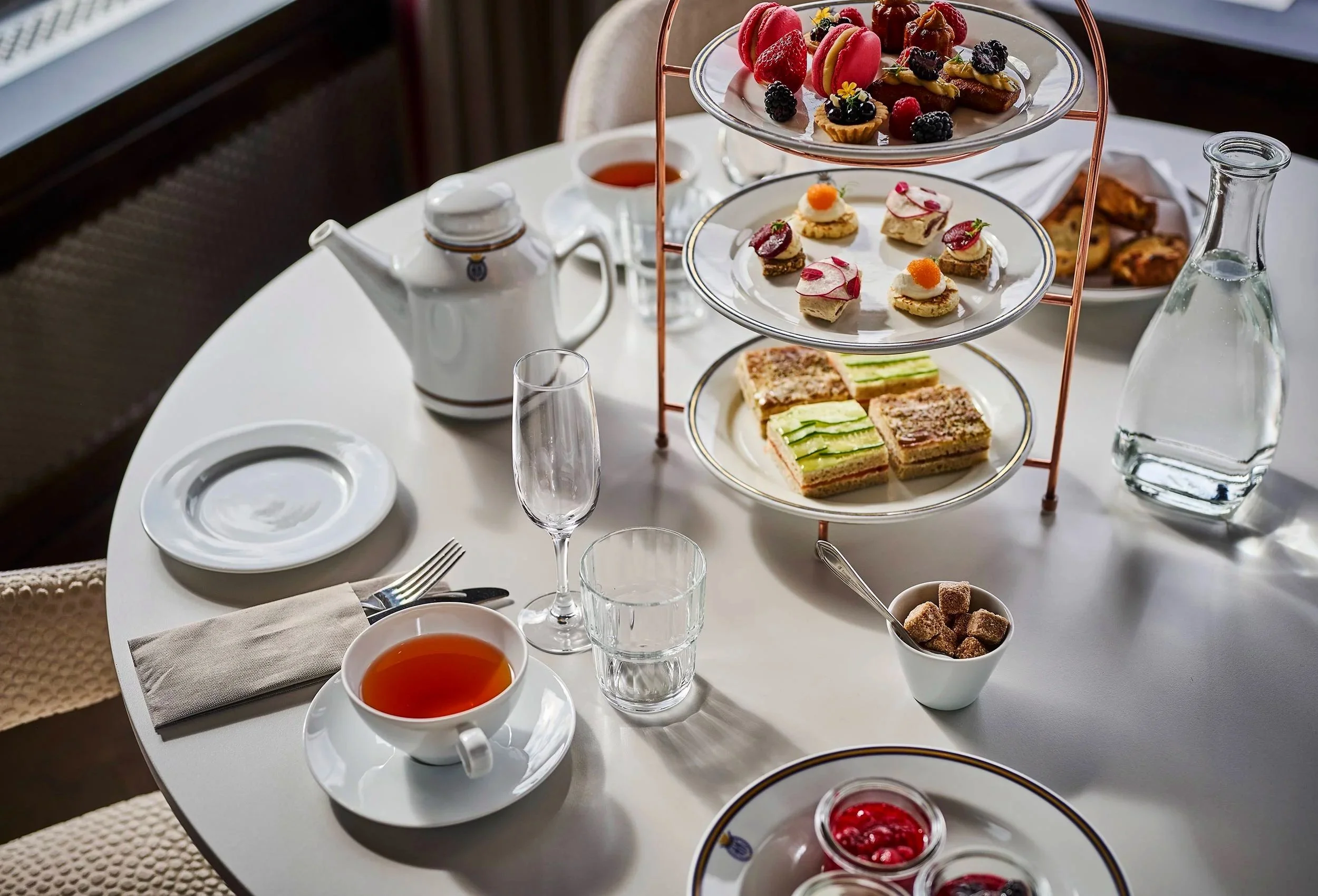 cafe table with high-quality tea, sandwiches and cookies
