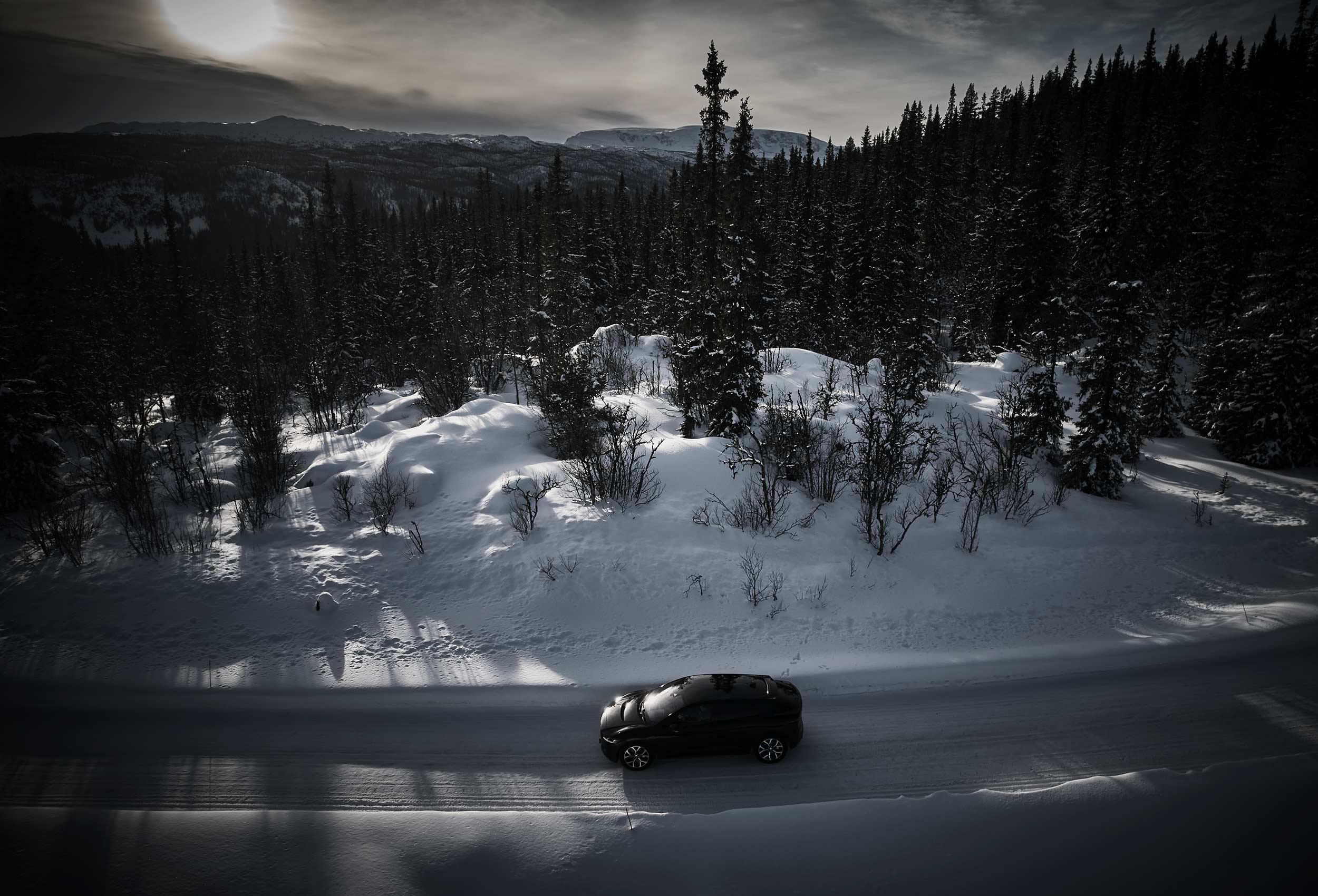 Jaguar I-PACE Land Rover in snow-covered landscape. Car photography and drone video in Norway