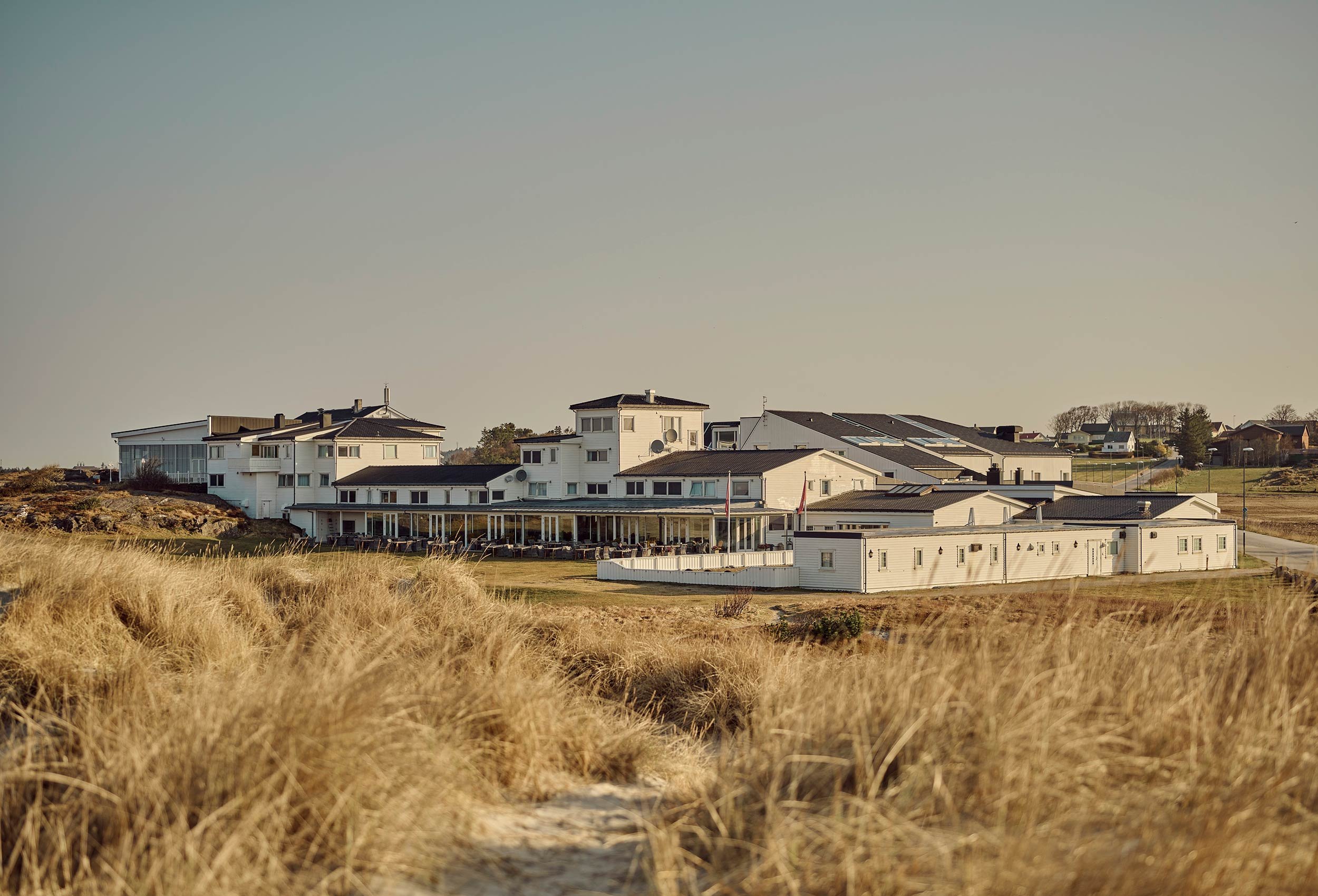 Picture of the Sola beach hotel and spa seen from the beach on a summer evening