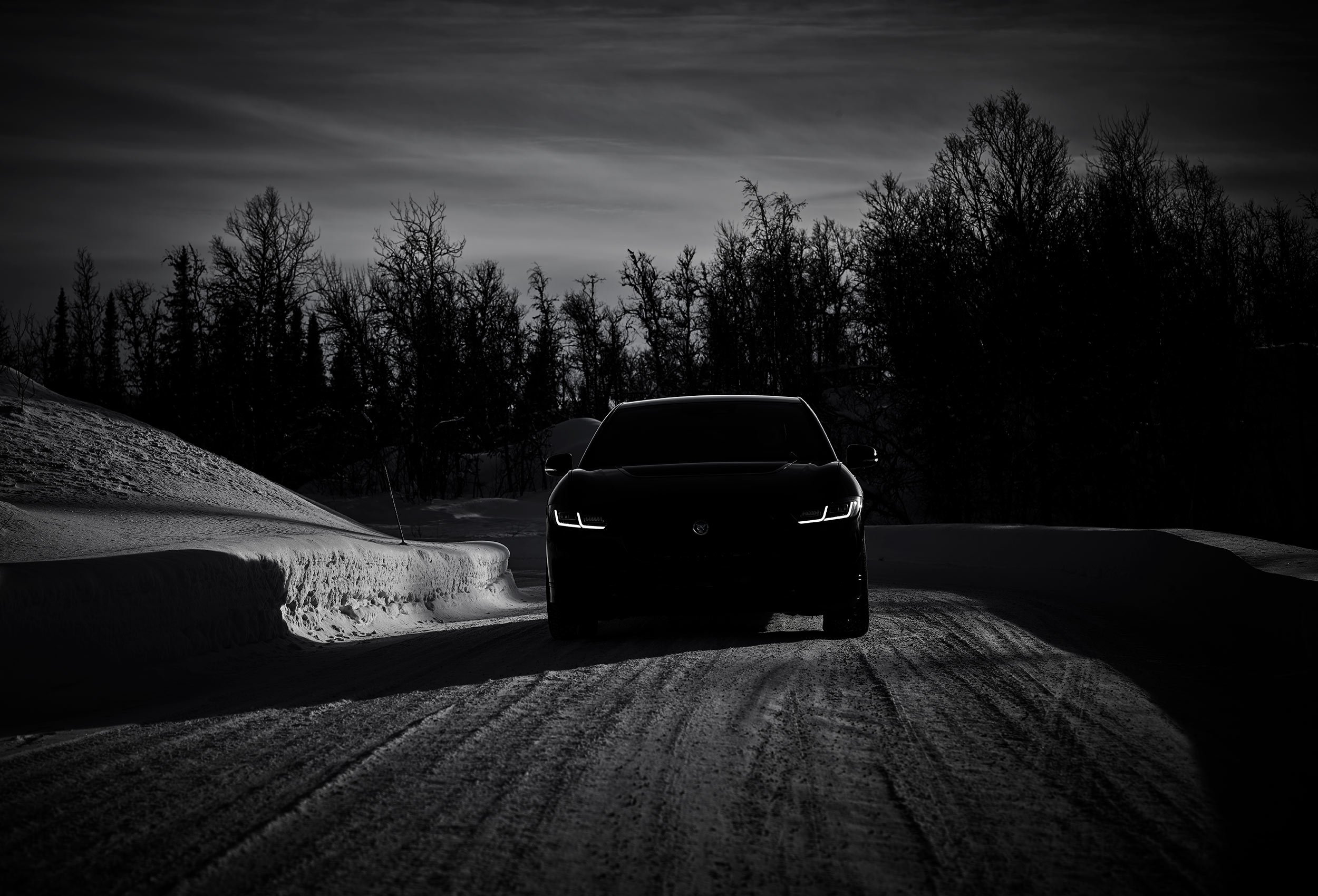 Jaguar I-PACE Land Rover in snow landscape with trees. Car photography and drone video in Norway