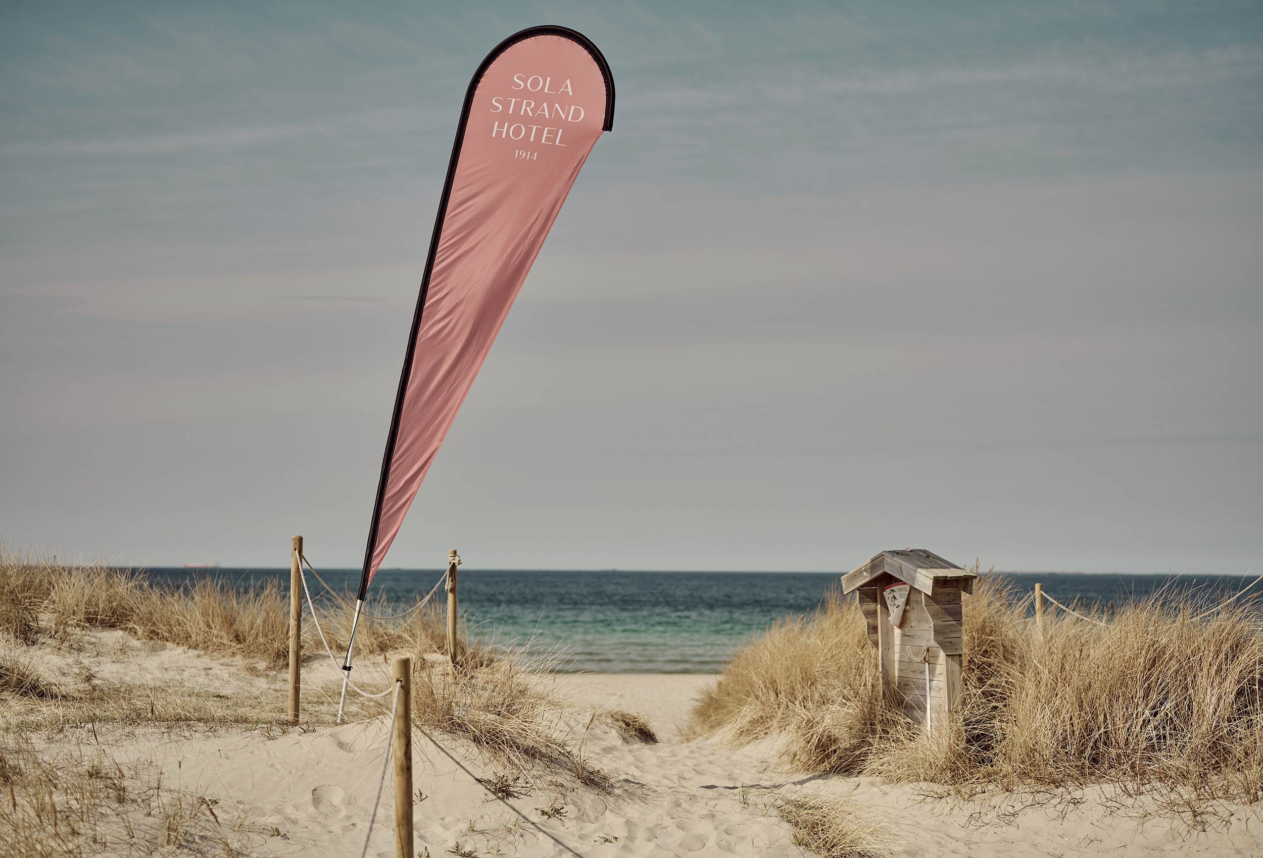 Flag on the beach with the logo of the sola beach hotel and spa at sunset on a summer evening