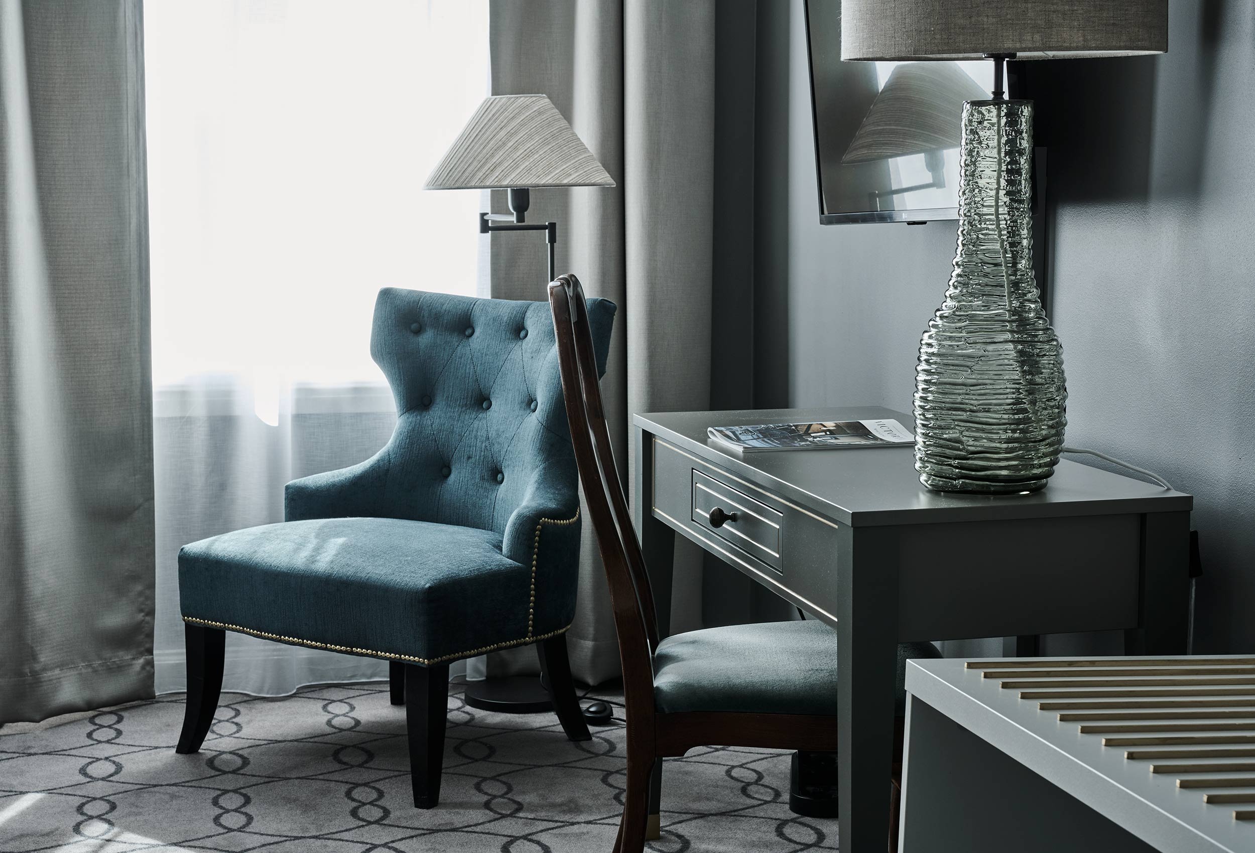 Close-up of arm chair and designer lamp in luxury hotel suite living room