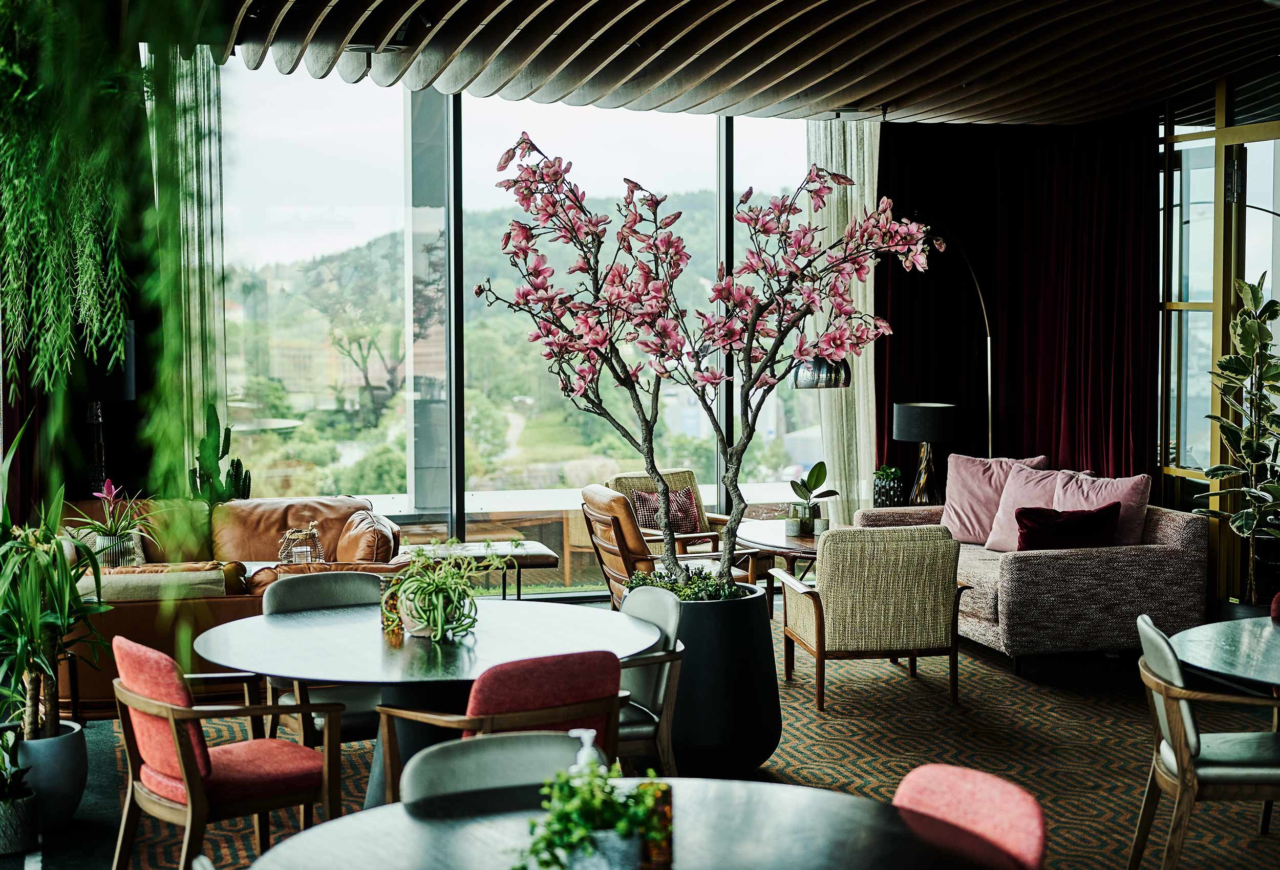 Lovely garden view from the restaurant at Radisson Blu Caledonien Hotel, Kristiansand with modern Scandinavian furniture and tiled walls