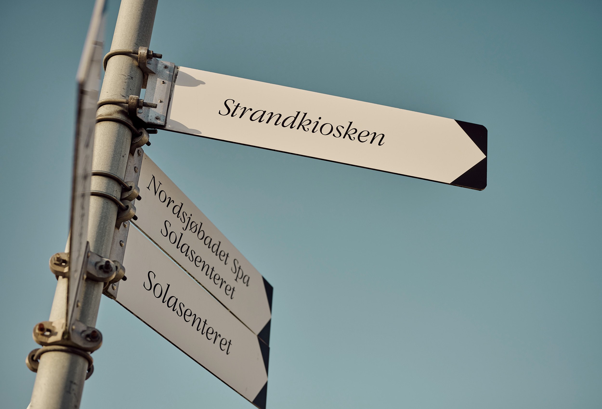Close-up of the road sign showing the direction to the beach and the ice cream kiosk at the sola beach hotel and spa
