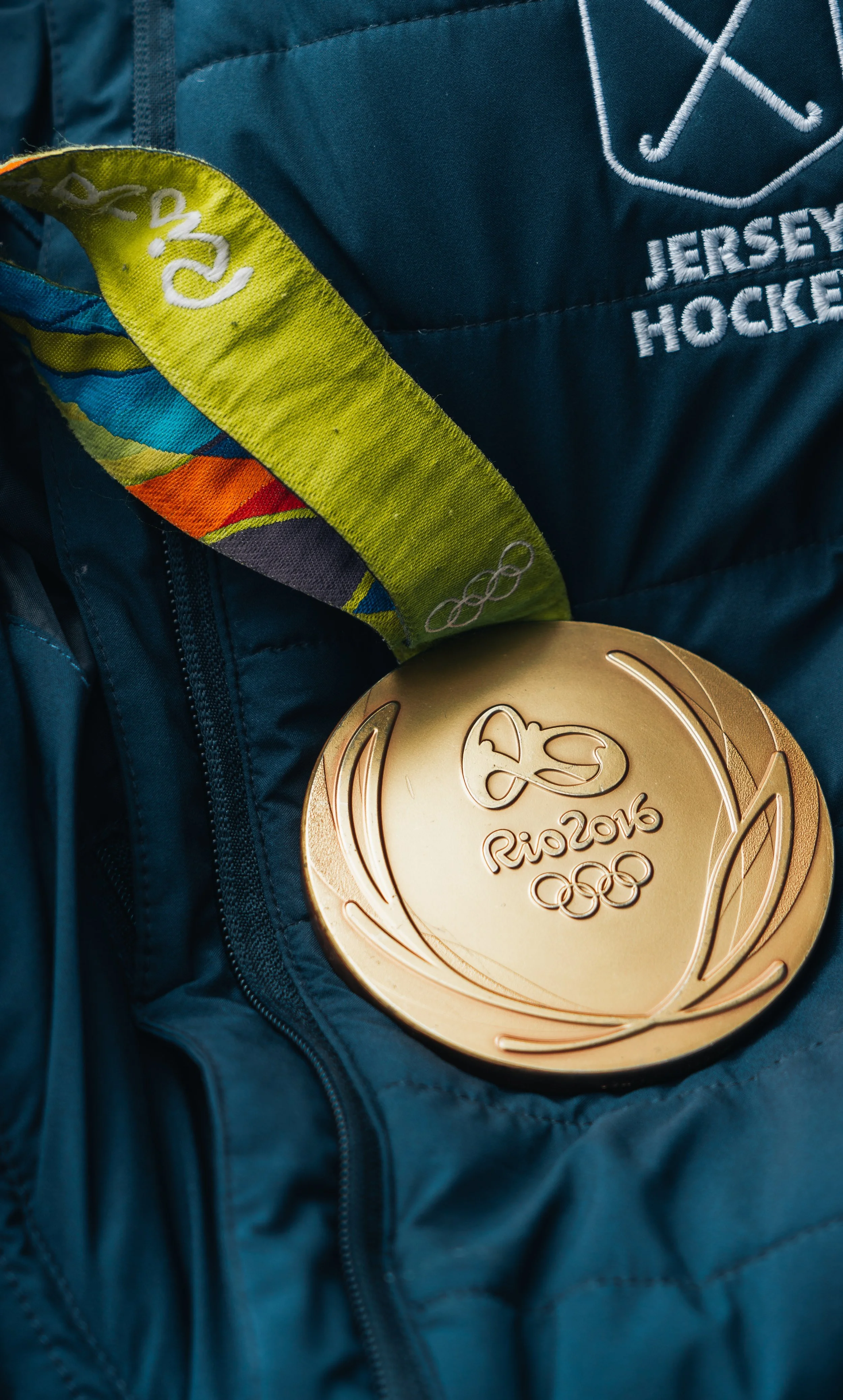 Close-up of a gold Olympic medal from the Rio 2016 Olympics hanging on a blue jacket