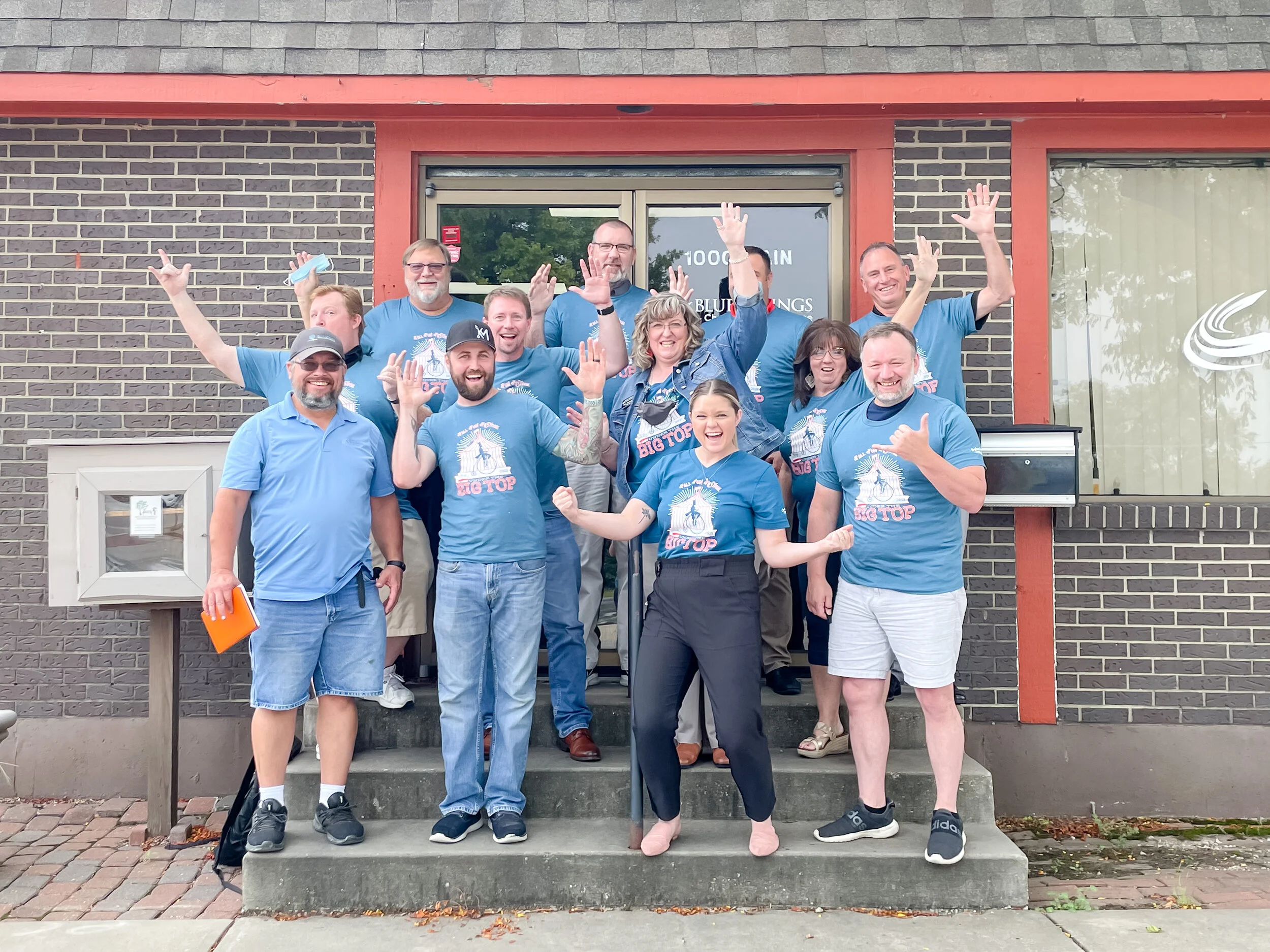 Group of festival volunteers cheering in front of the Chamber of Commerce building