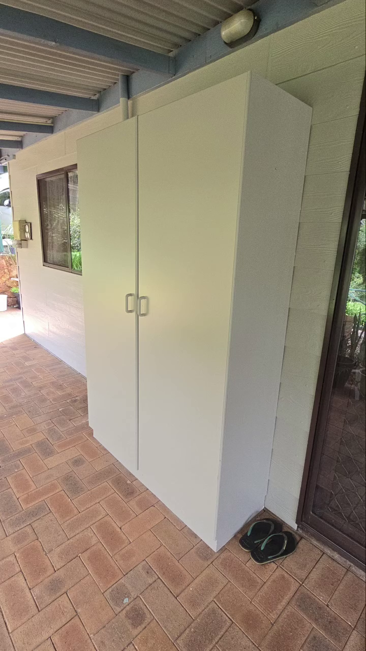 Freshly painted white outdoor storage cupboard on a brick-paved patio by painters in Bickley.