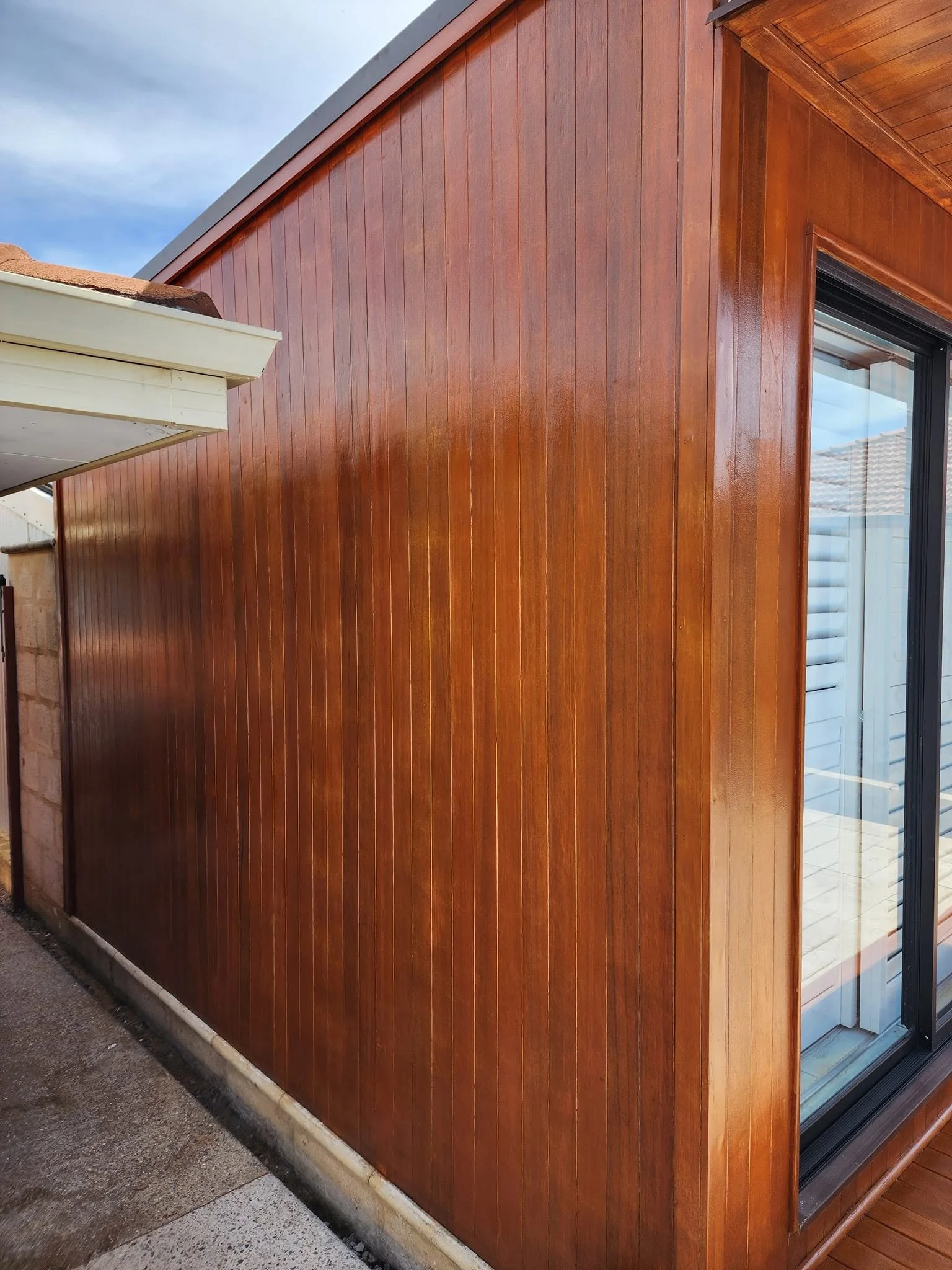 Rich, warm timber stain applied to exterior wood cladding on a studio by Perth Paints.